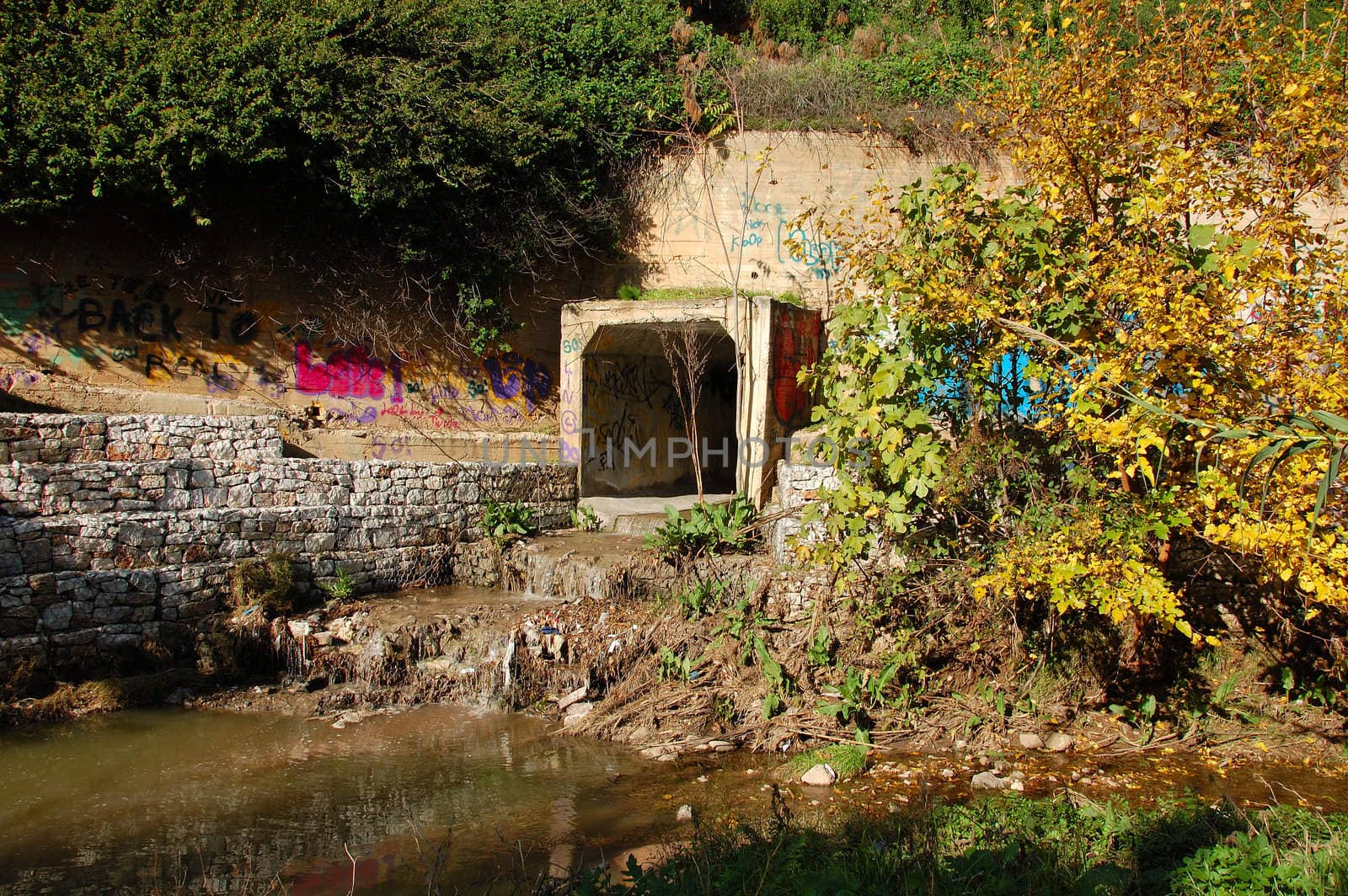 Waste water and sludge from a drain contaminating a small river.