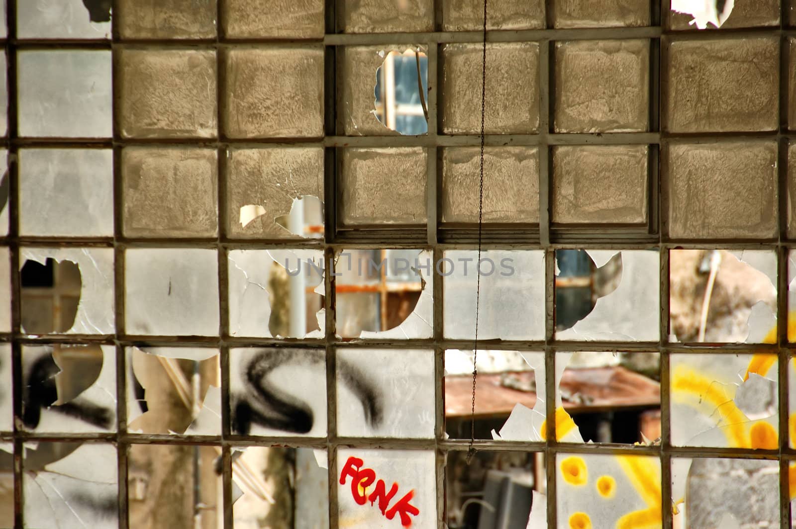 Broken windows in a partially demolished abandoned factory.