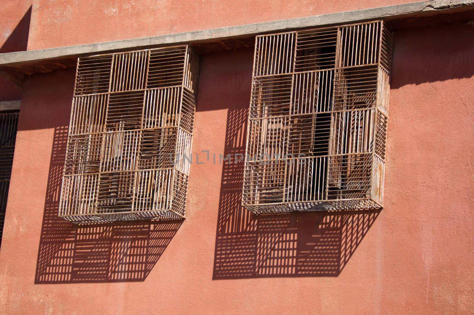 Old barred windows with great shadows in Marrakech, Morocco