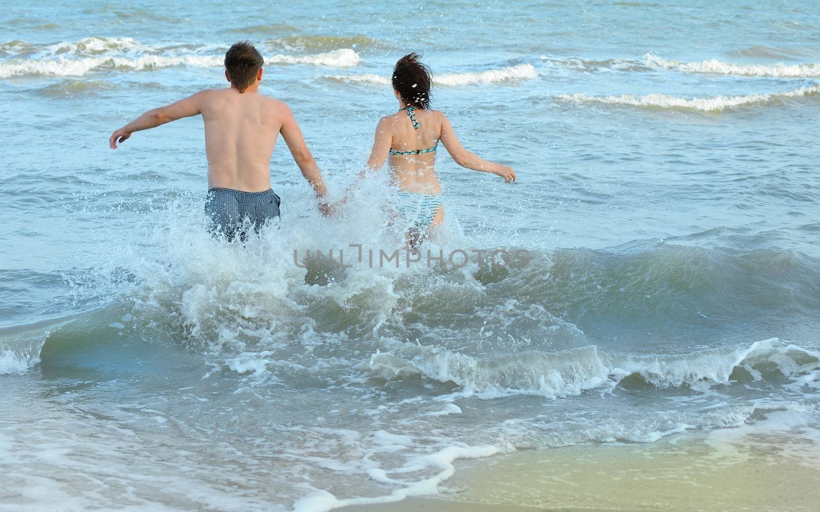 Pair on seacoast. The enamoured guy and the girl walking on coast