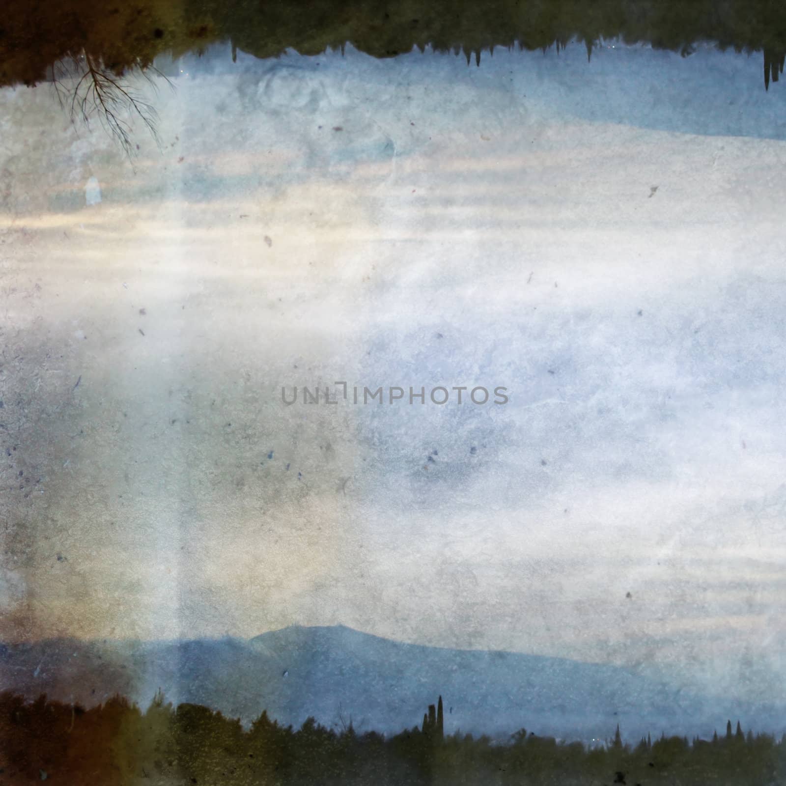 Double printed vintage discolorated photograph of trees, distant city lights and mountain horizon. Abstract illustration.