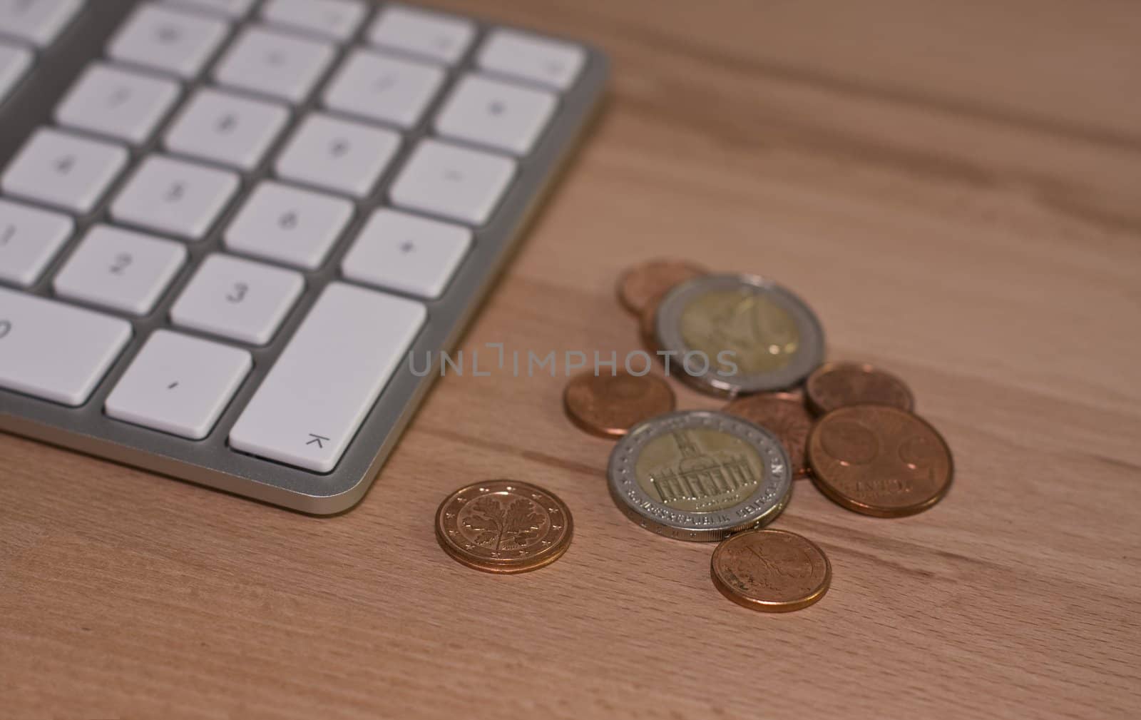 Keyboard and euro coins on wooden desk with nice blur. Place for text
