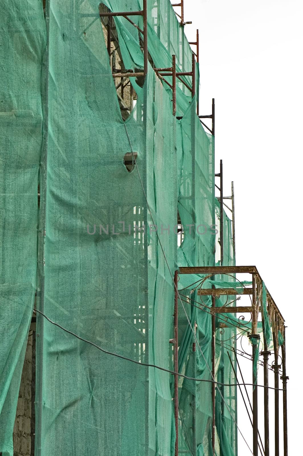 Abandoned 19th century mansion renovation. Torn scaffold debris netting.