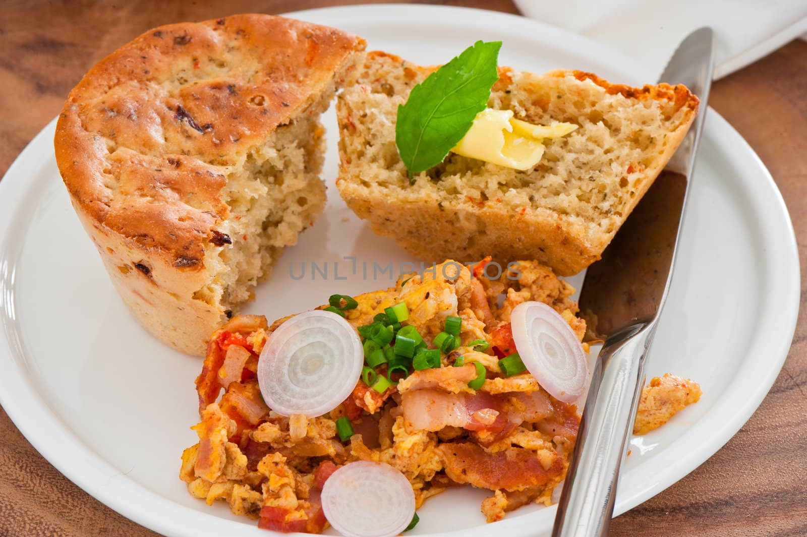 Homemade mediterranean bread with butter scrambled eggs and a leaf of basil