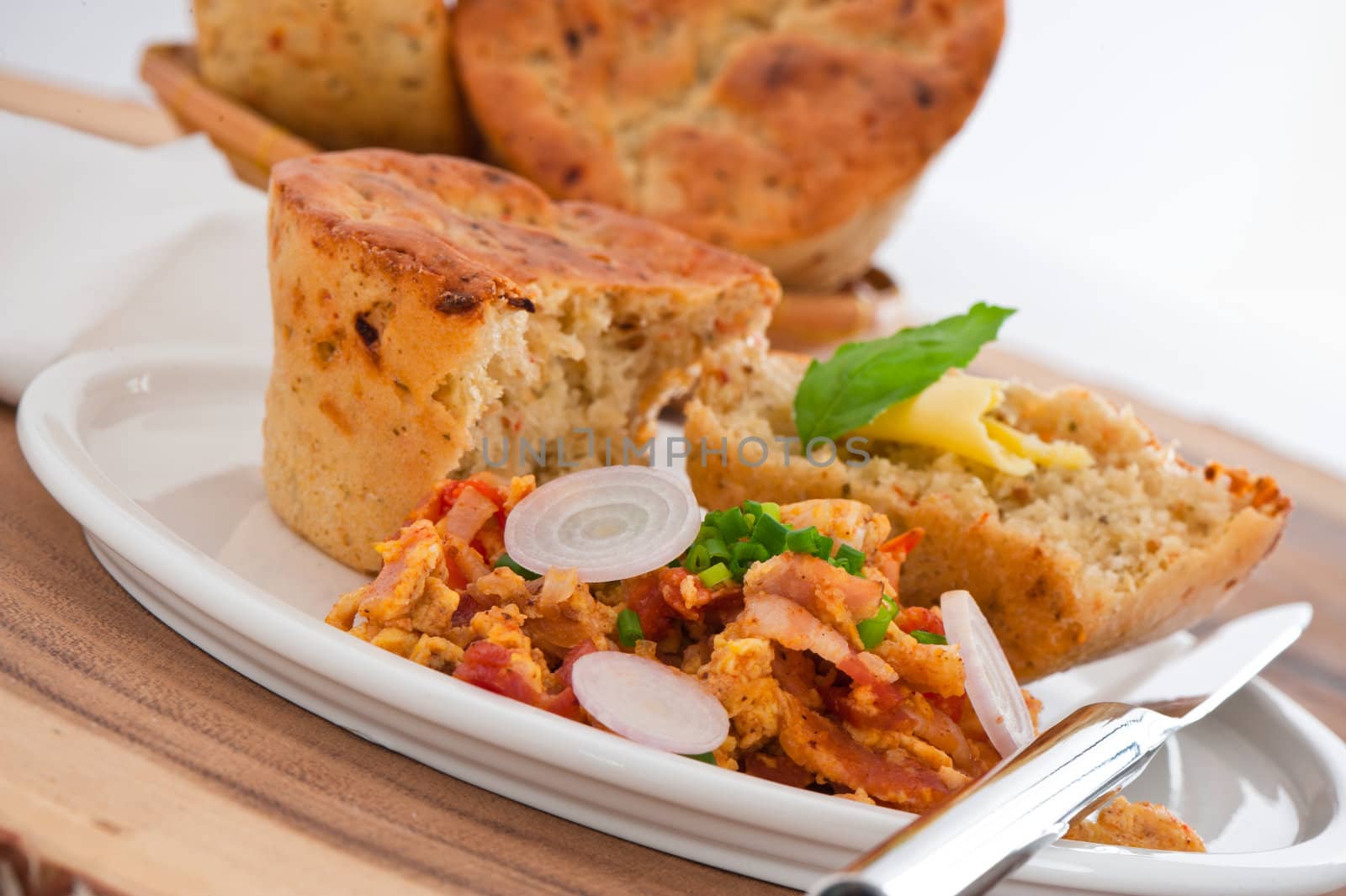 Homemade mediterranean bread with butter scrambled eggs and a leaf of basil