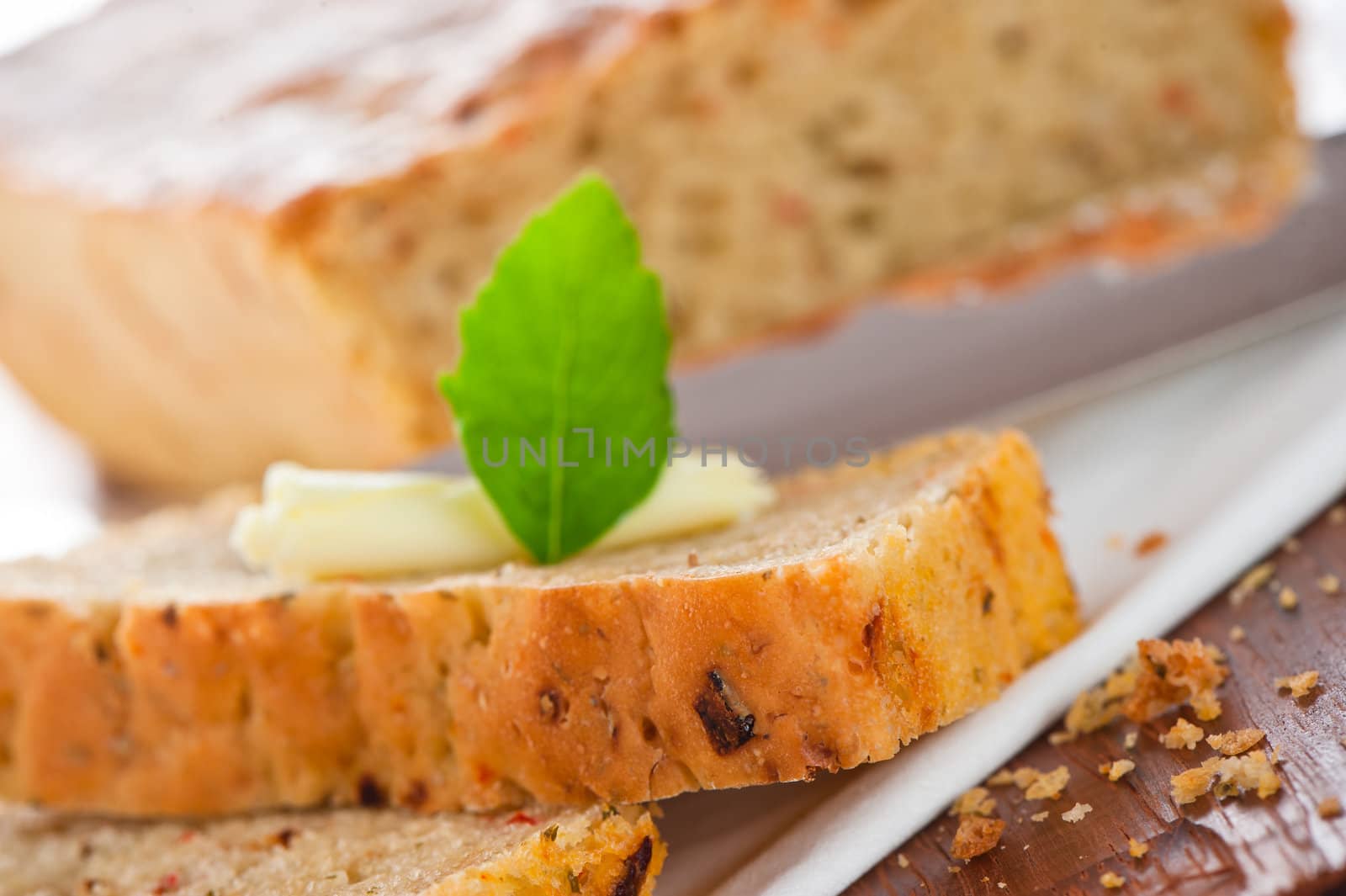 Homemade mediterranean bread with butter and a leaf of basil