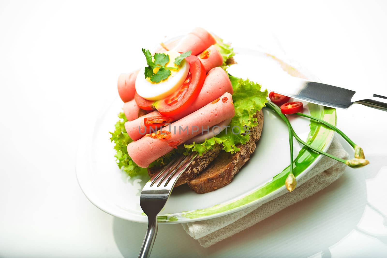 Brown bread with chili sausage slices green salad tomato and egg