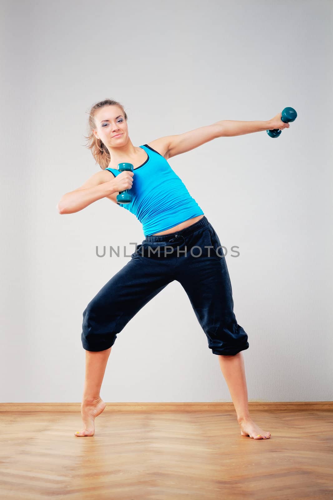 Young woman to training of athletic exercise with dumbbells