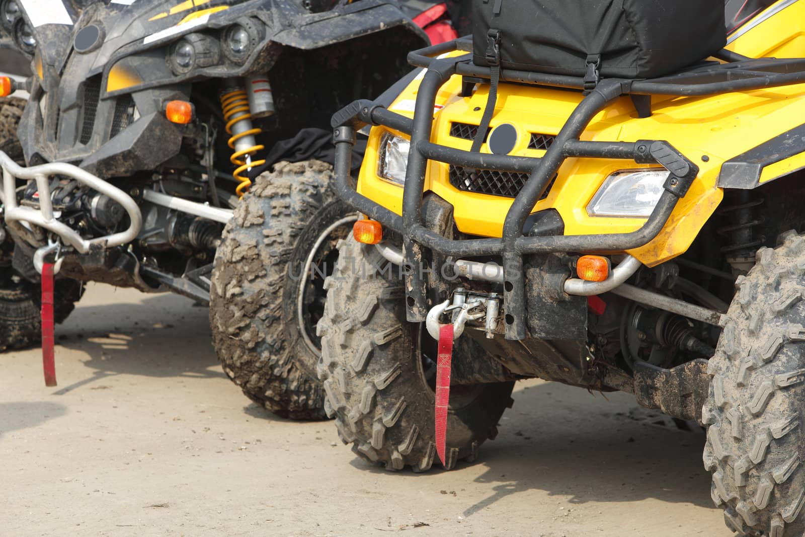 Low angle veiw of the front part of a row of ATVs.