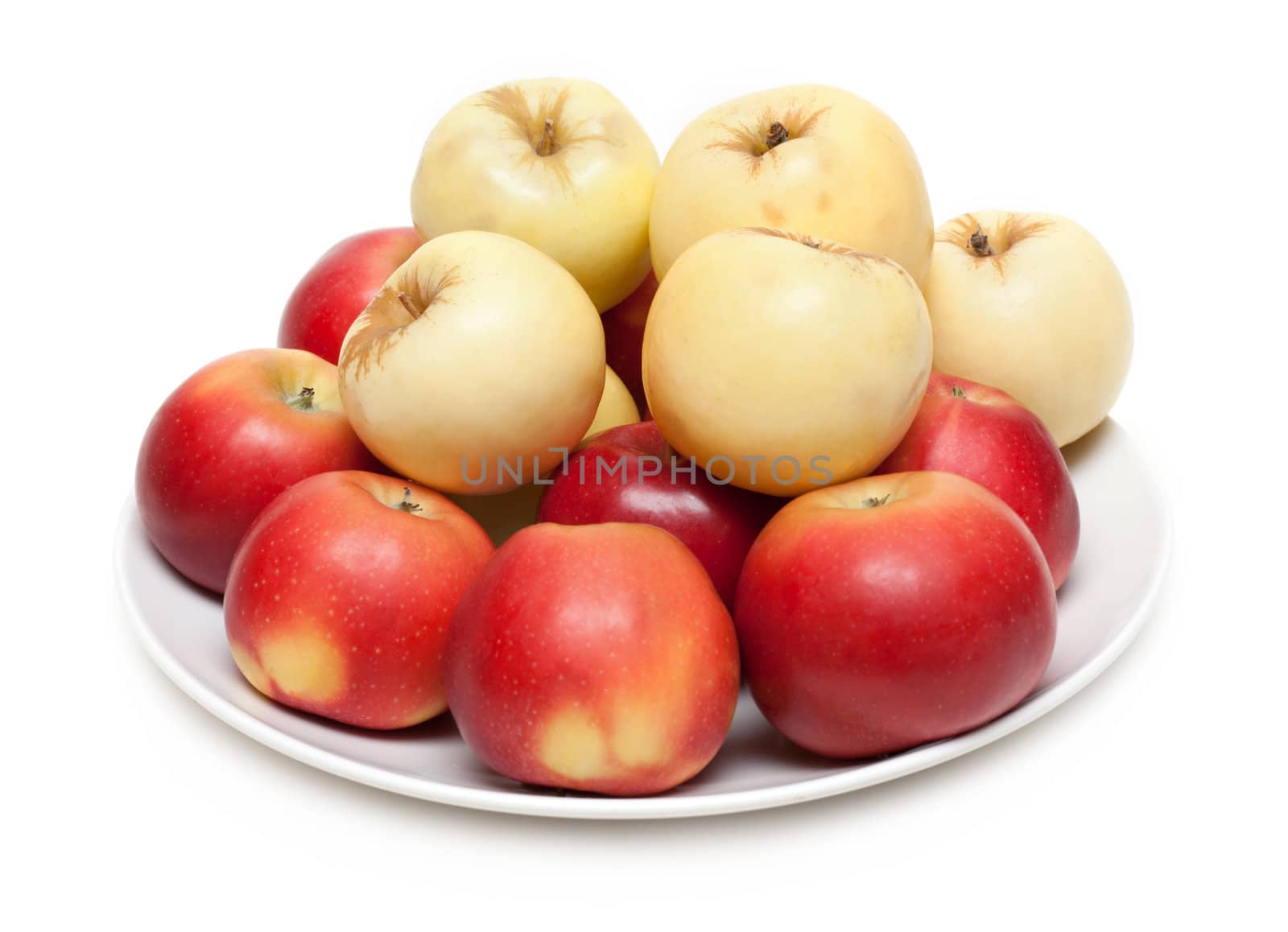 Red and yellow apple on plate on white background