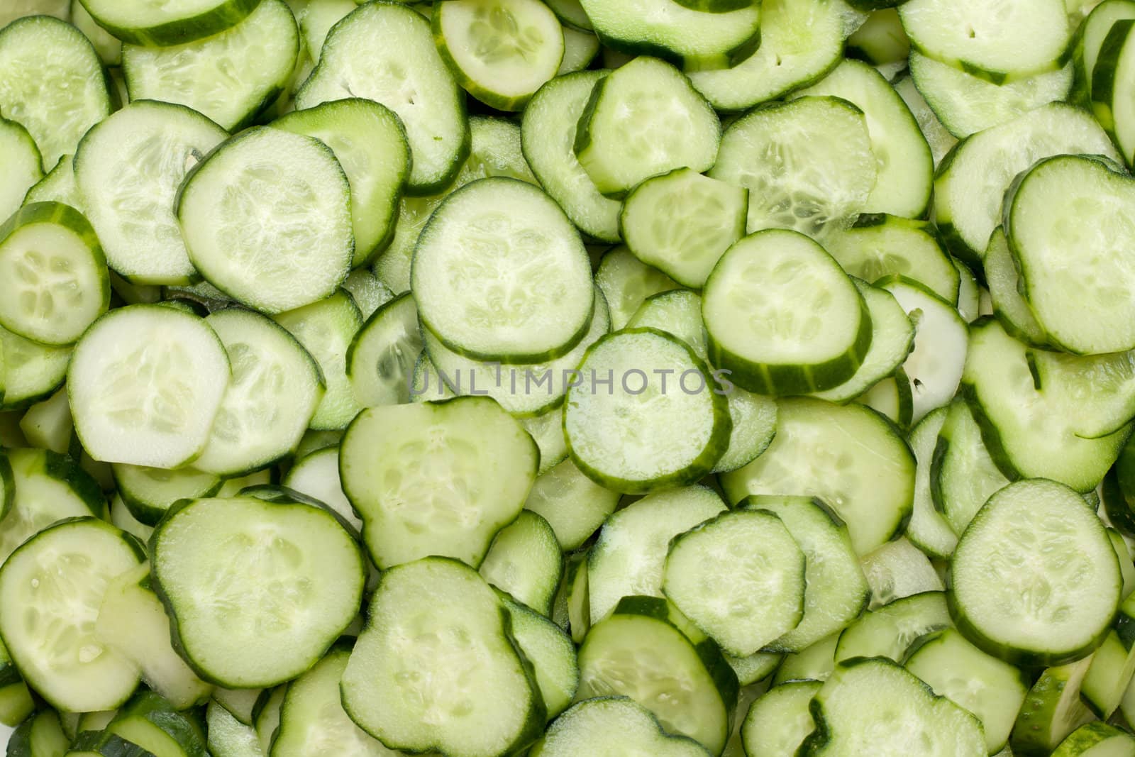 Much cut fresh cucumbers put by background