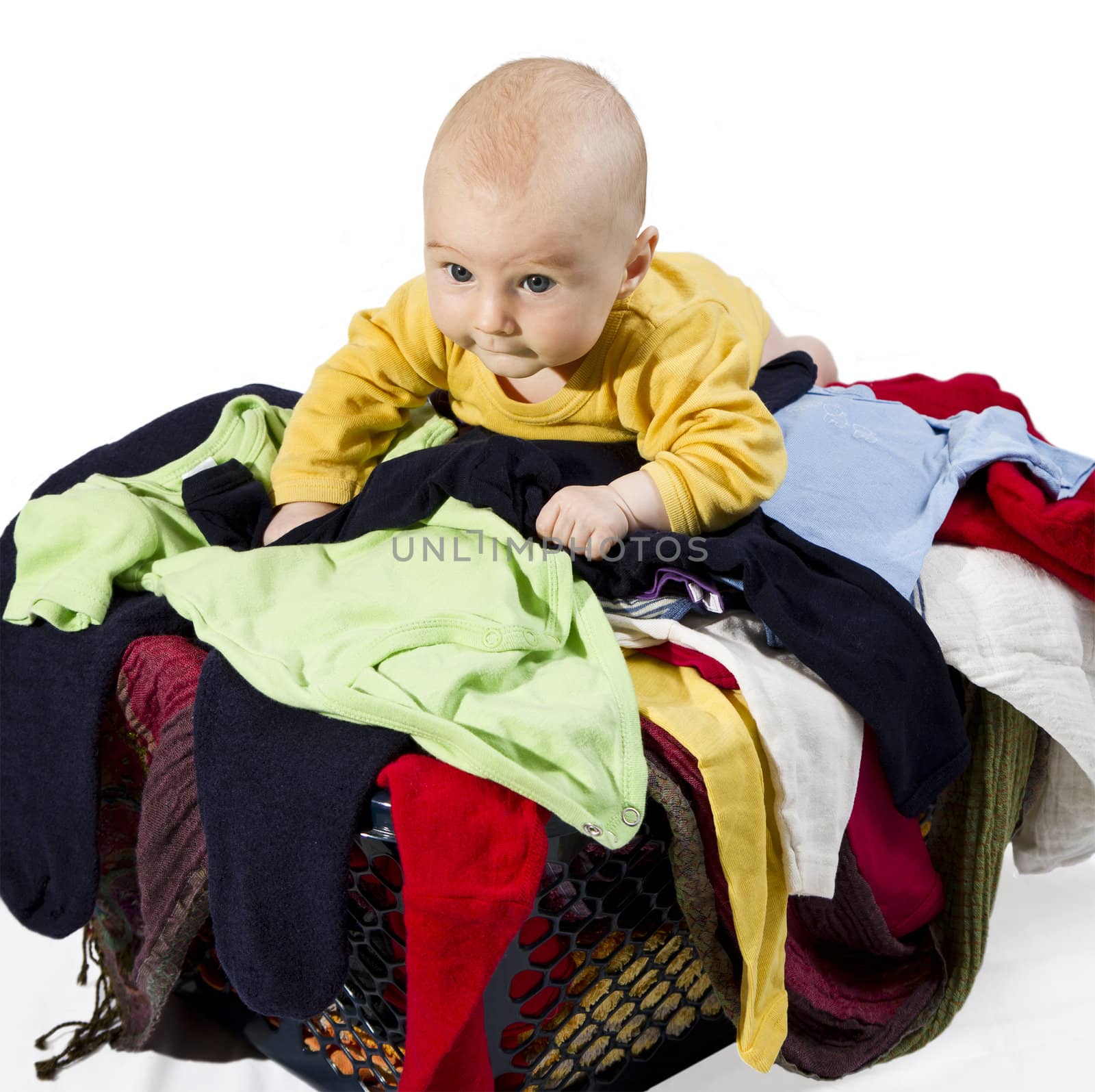 young child on many clothes in clothesbasket isolated on white background