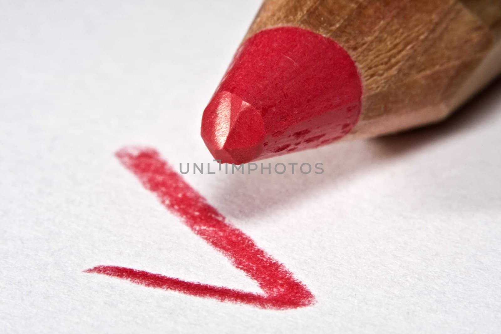 Red pencil with check mark on paper, macro