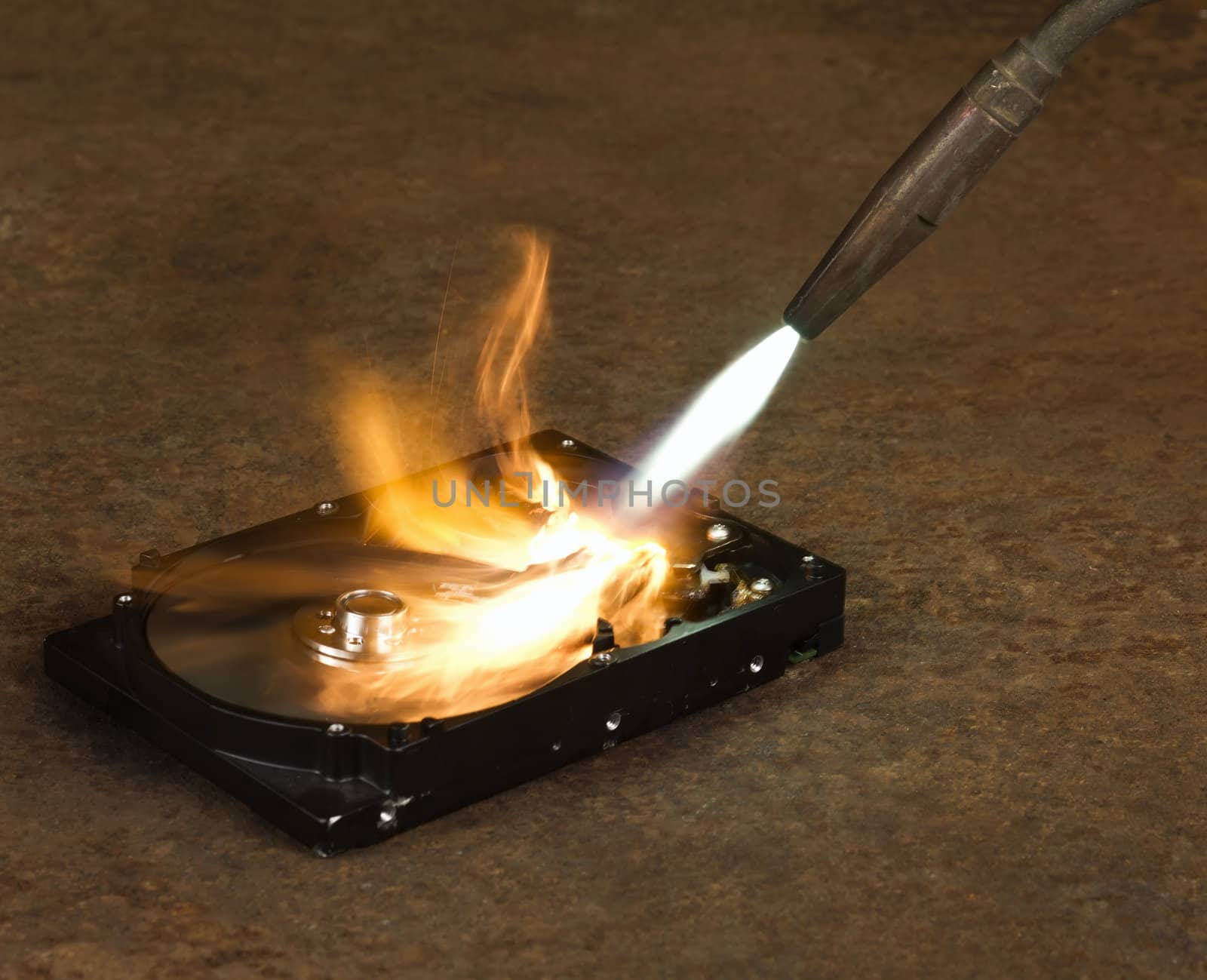 burning a hard disk drive with a welding torch in rusty background