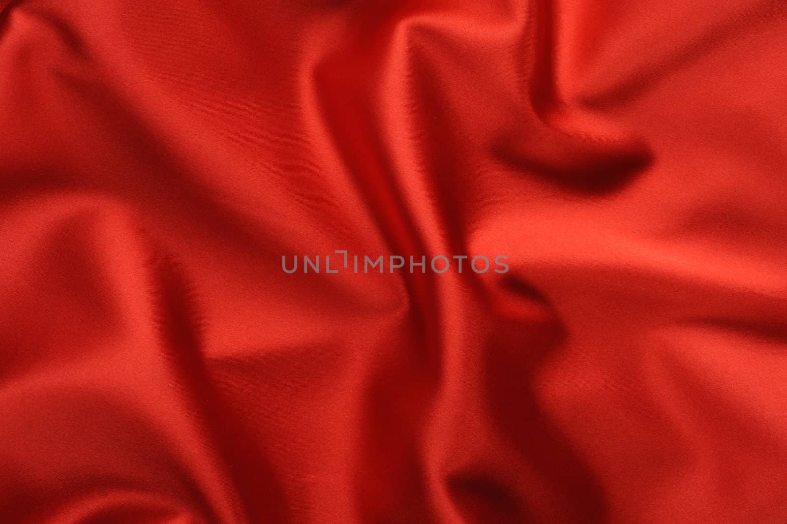 red satin background. A satiny fabric with beautiful light-shadow waves