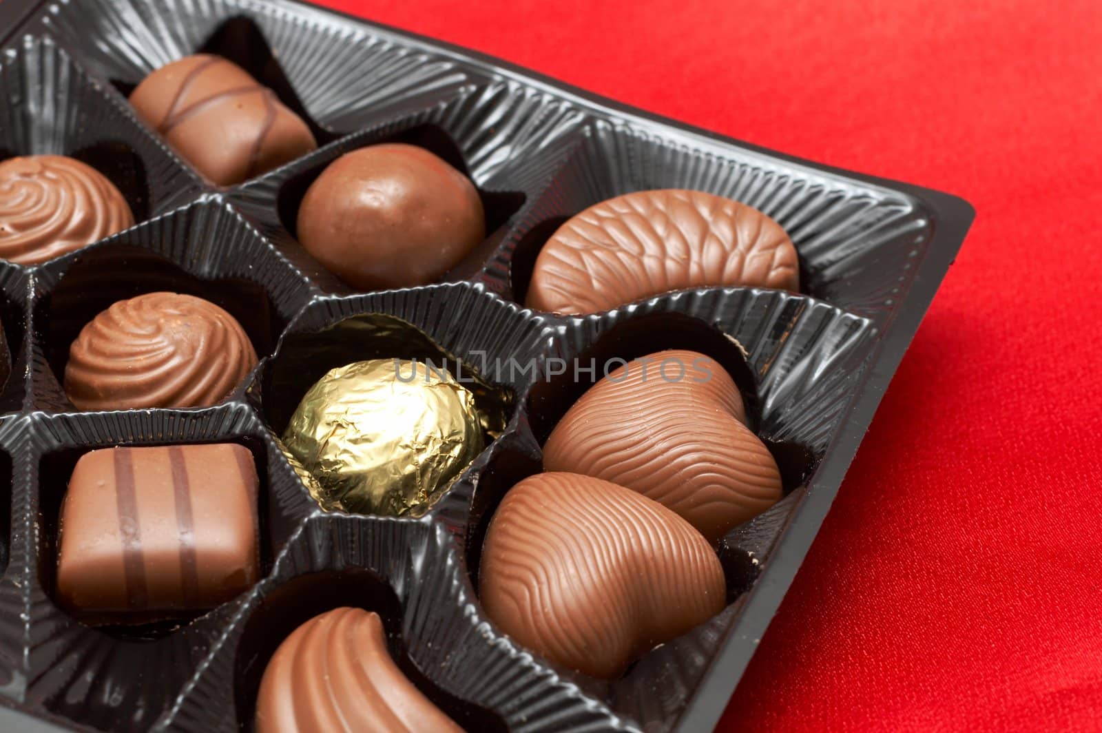 Assortment of Valentines chocolates in box on red silk