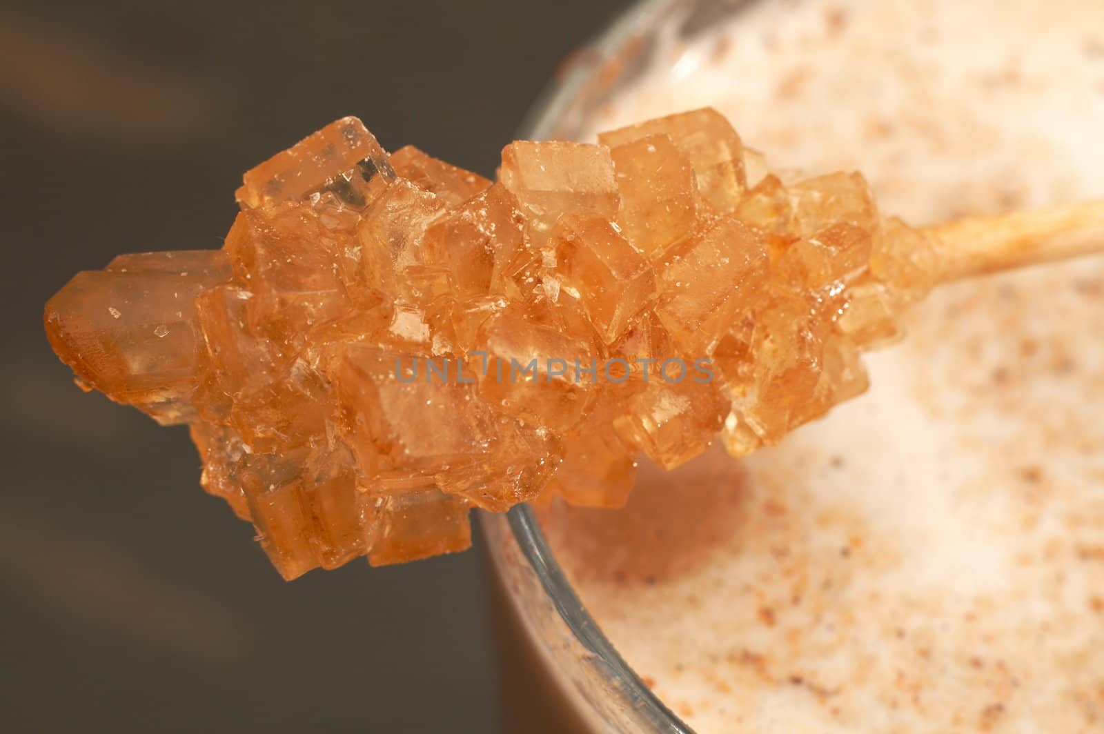 Macro shot of sugar stick on cafe latte with foam