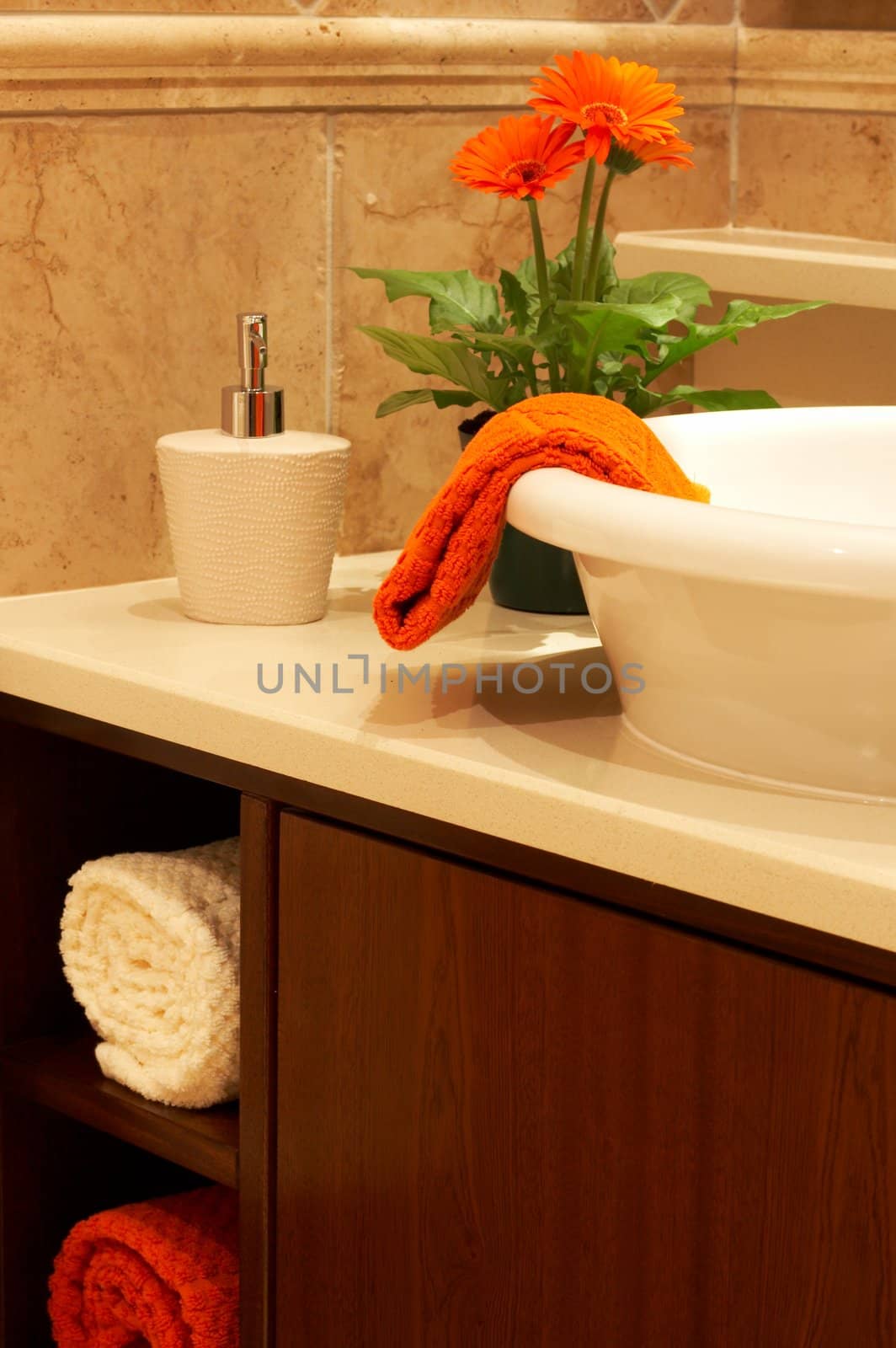 Beautiful sink in a bathroom with towel on it and a flower