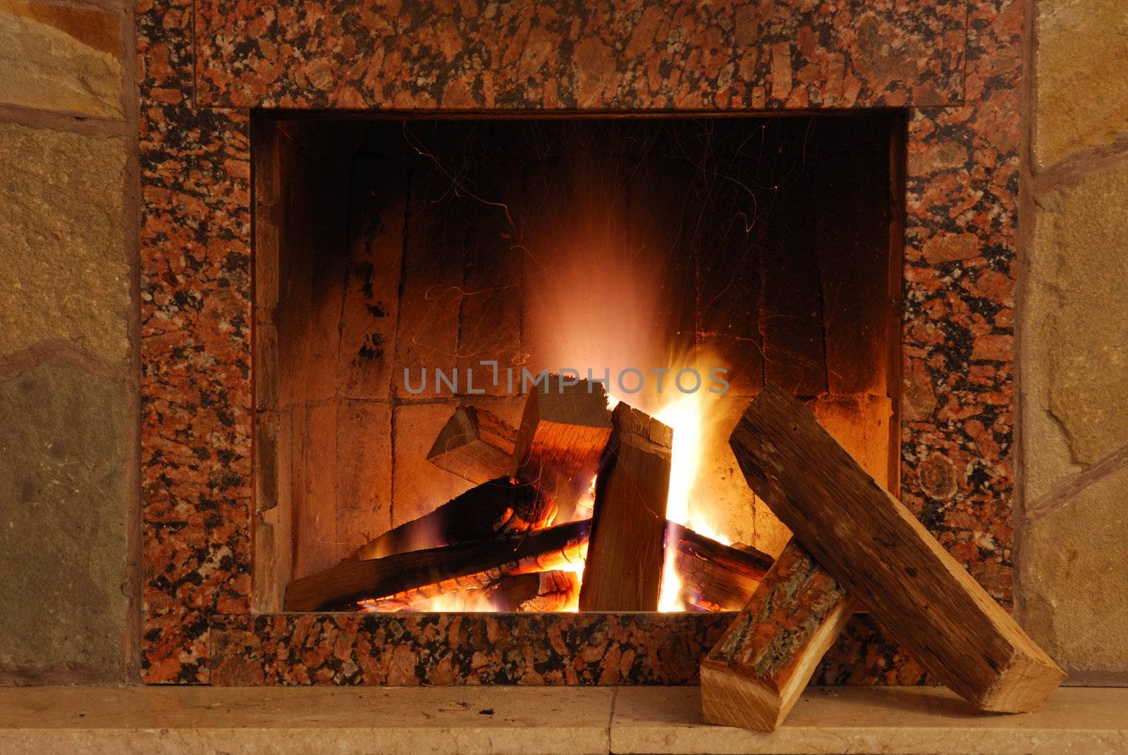 Fireplace. Flaring fire in a fireplace the reveted wild stone and a marble