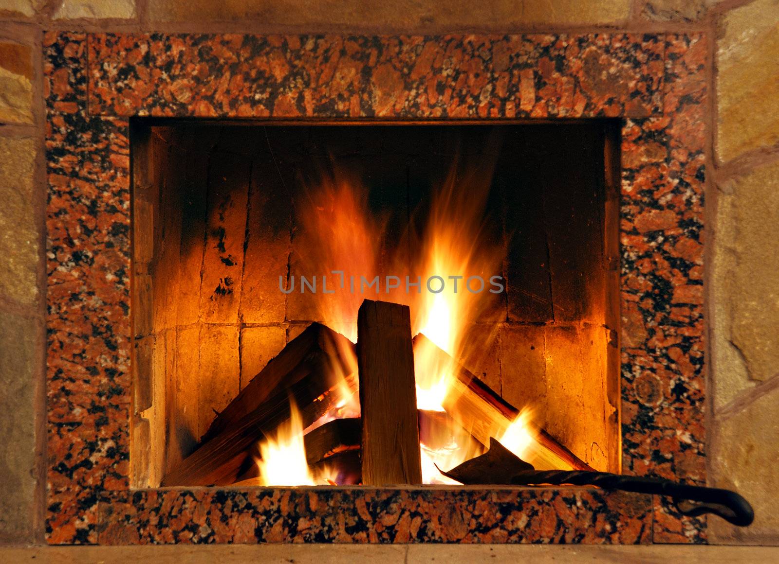 Fireplace. Flaring fire in a fireplace the reveted wild stone and a marble