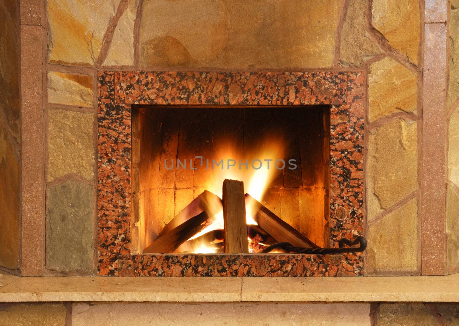 Fireplace. Flaring fire in a fireplace the reveted wild stone and a marble