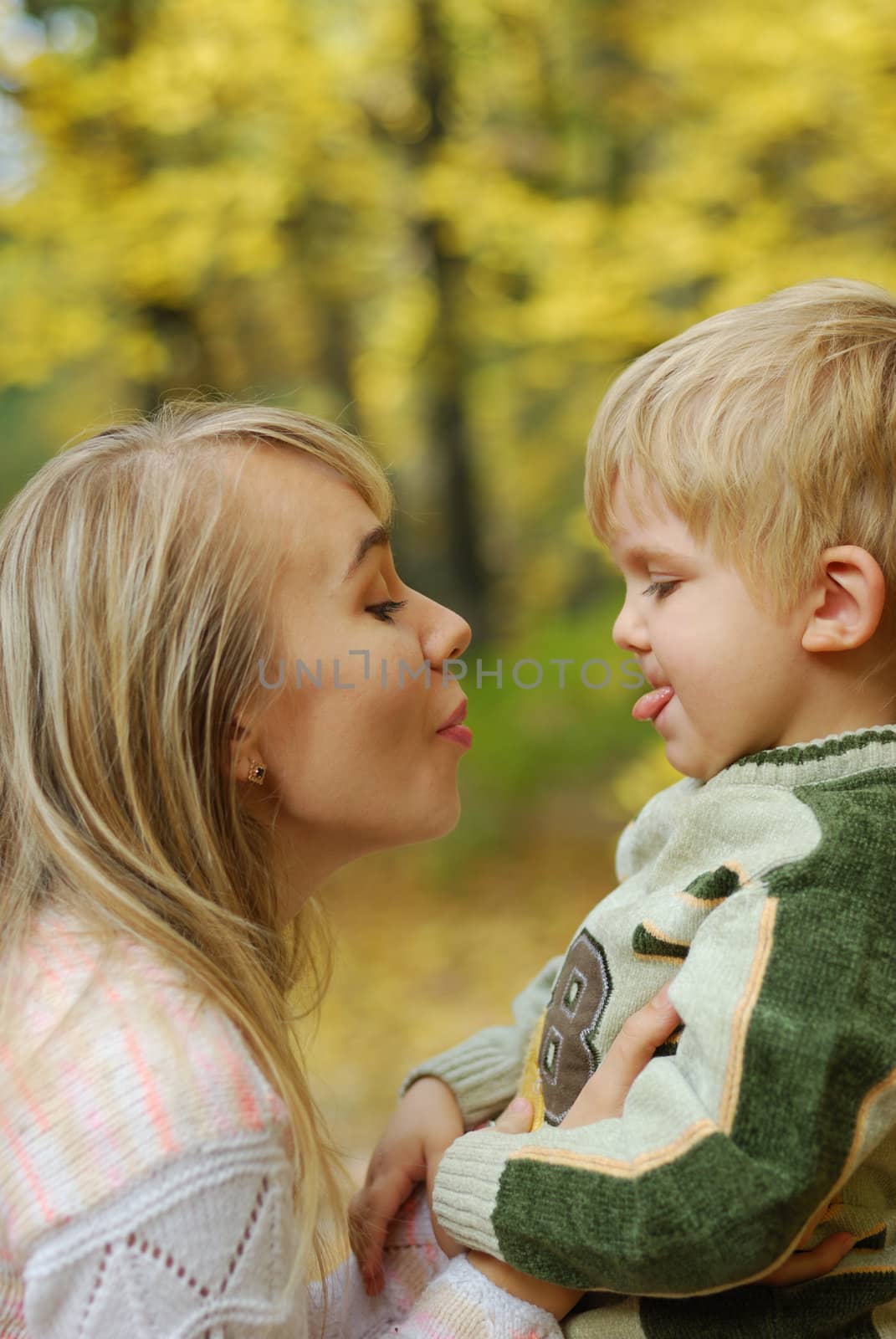 Mother with the child. On a background of yellow autumn foliage