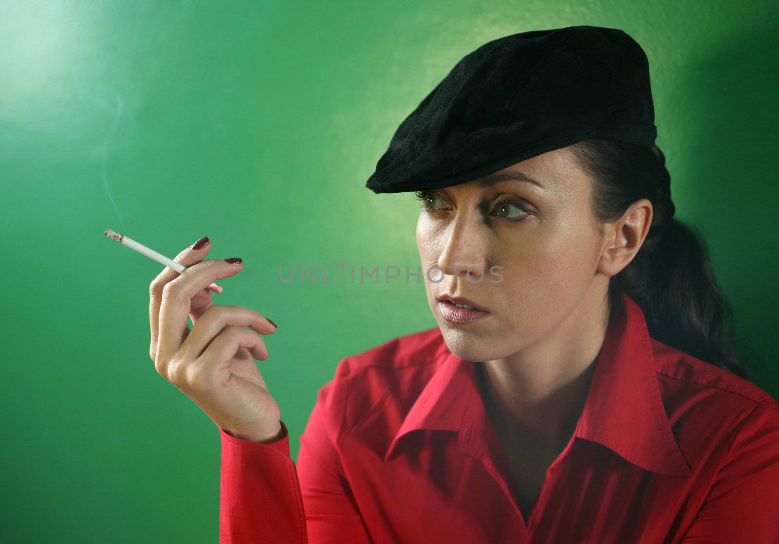 Woman with a cigarette on green background