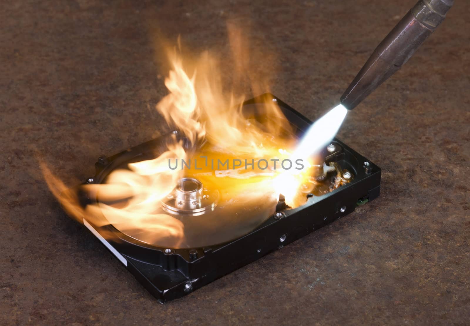 burning a hard disk drive with a welding torch in rusty background