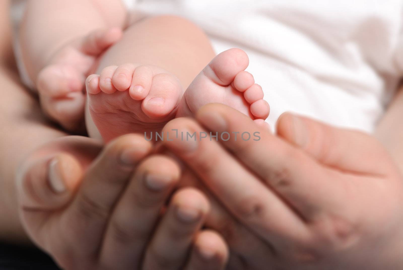 Foot the baby in adult hands. Age of the baby of 8 months.