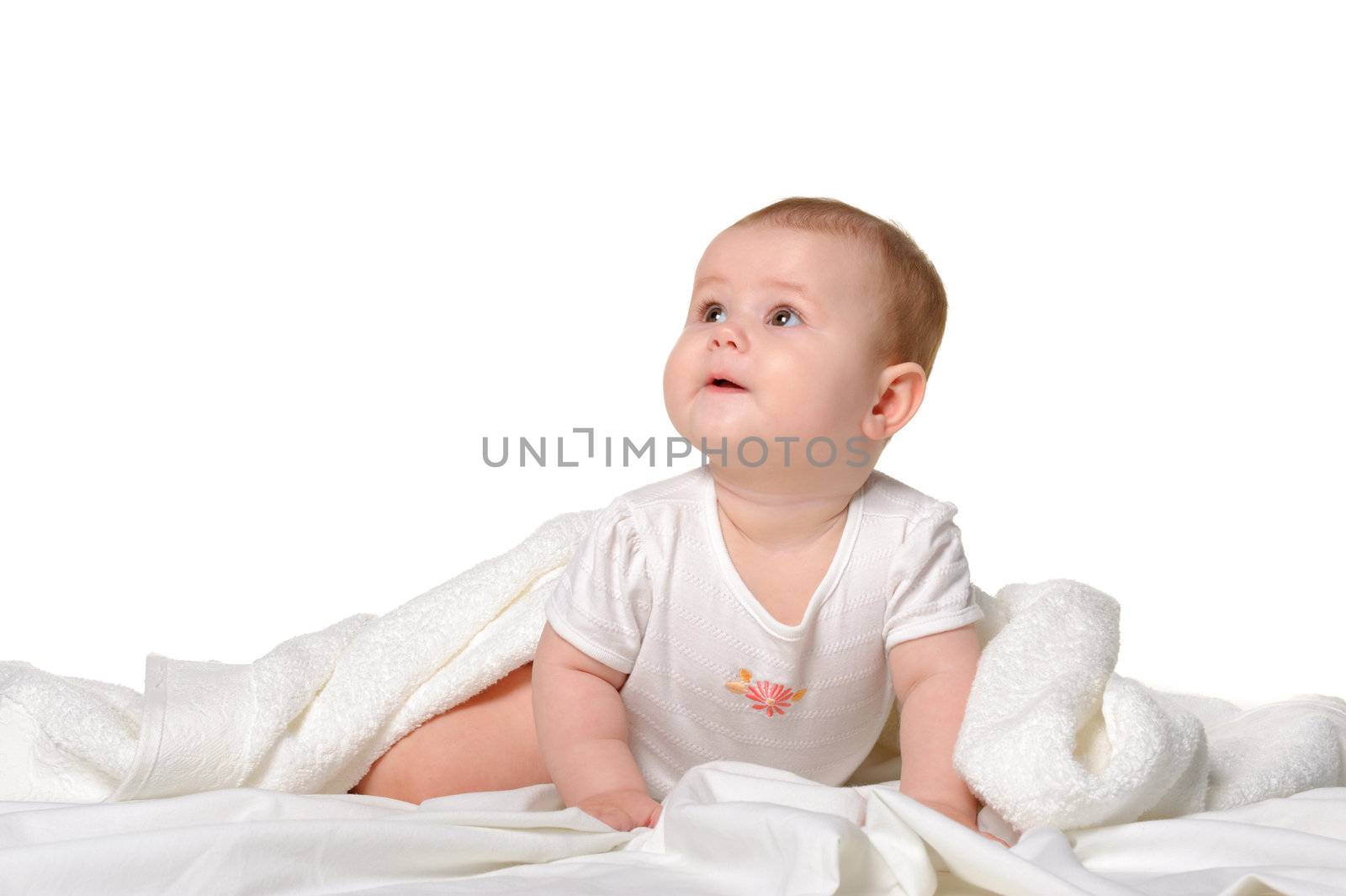 The baby under a towel. Age of 8 months. It is isolated on a whi by galdzer