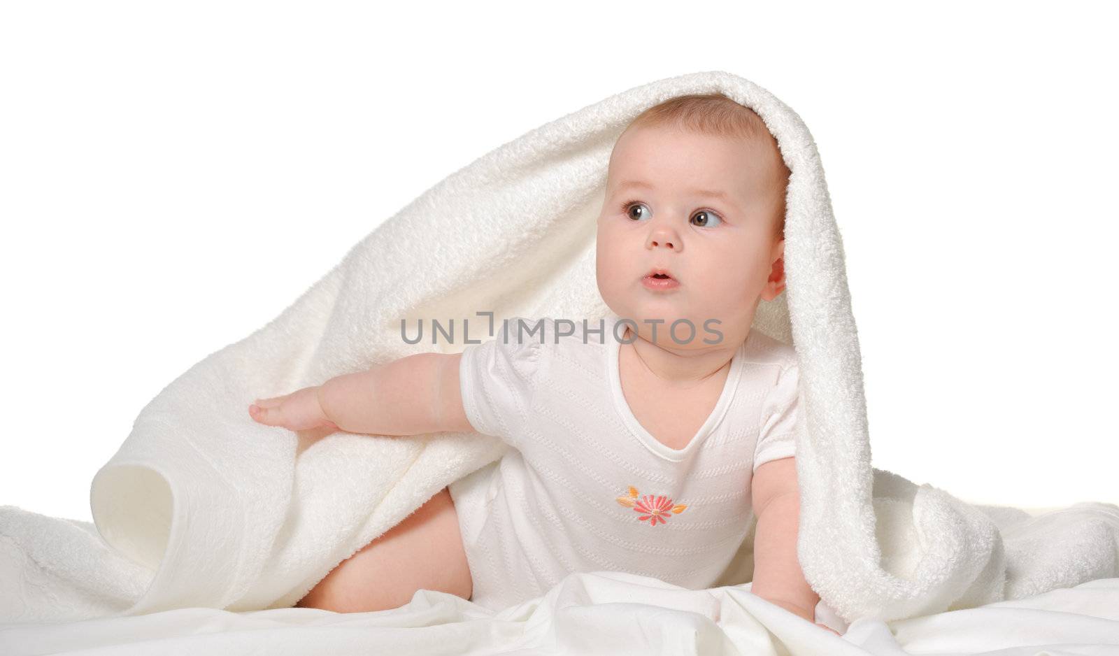 The baby under a towel. Age of 8 months. It is isolated on a white background