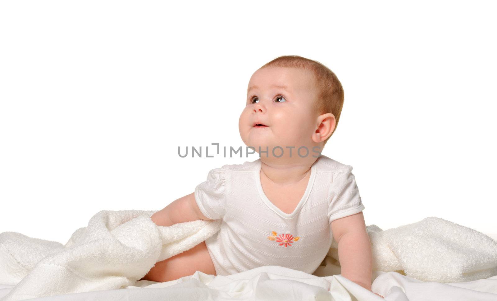 The baby on a bedsheet. Age of 8 months. It is isolated on a white background