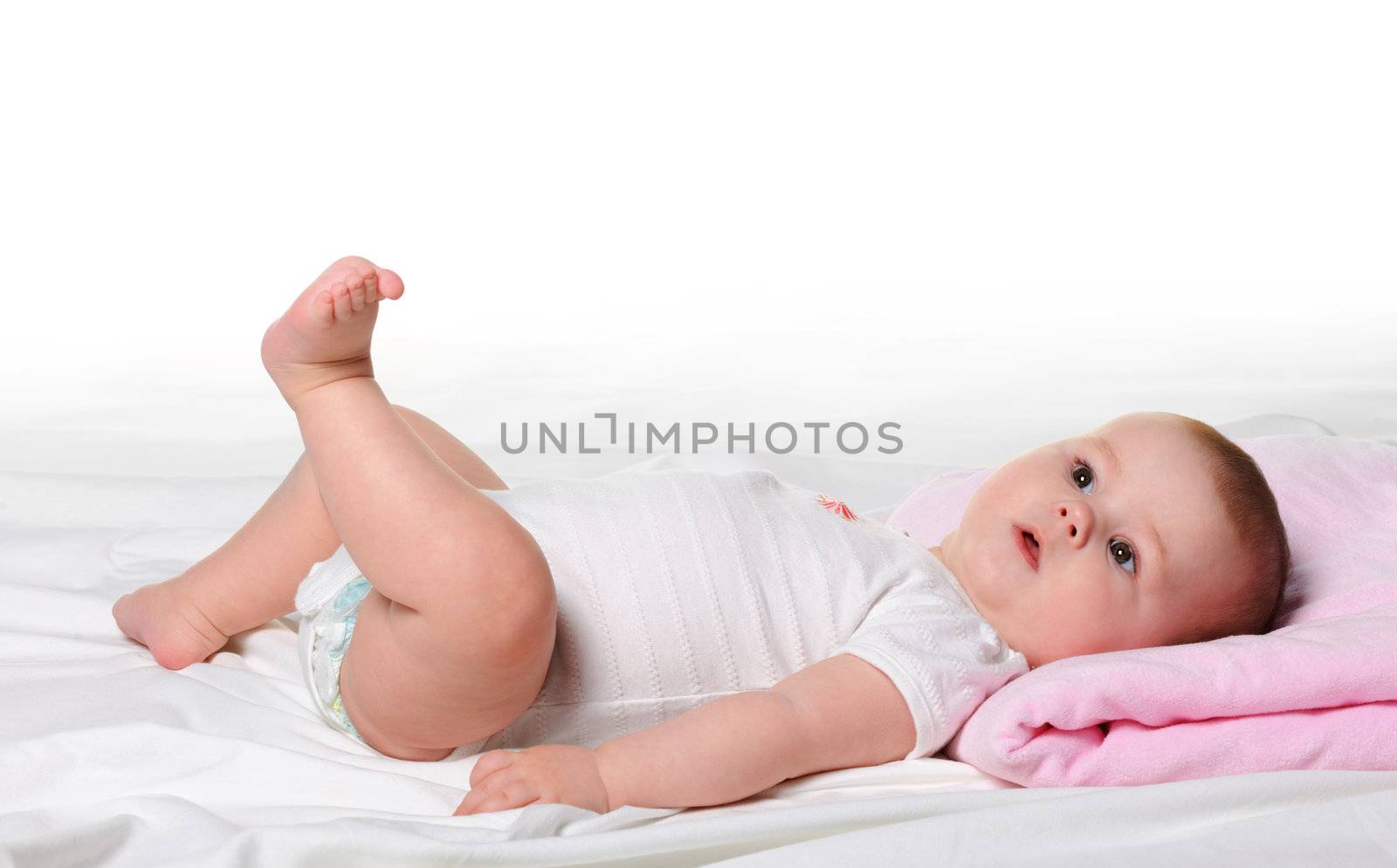 The baby lays. Age of 8 months. It is isolated on a white background