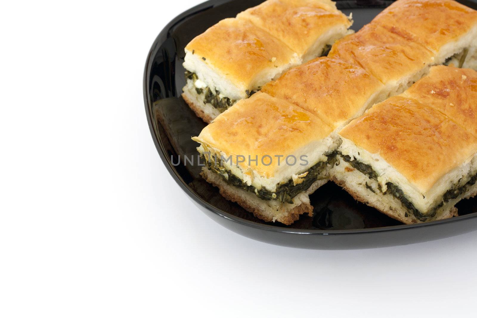 Pieces of spinach pie with cheese on white background