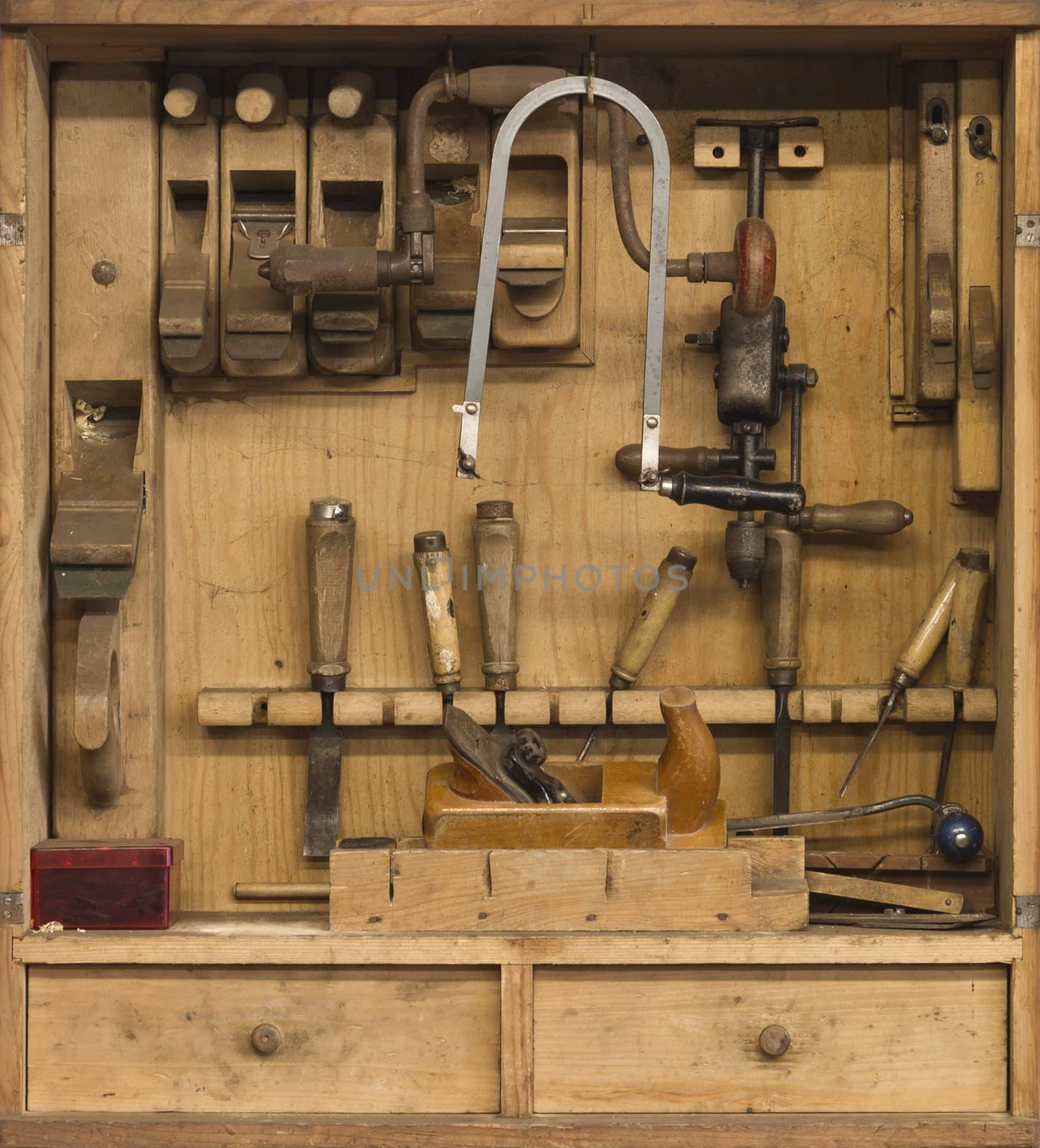 carpenters tools in a wooden cabinet. There are many tools like a planer, chisel, saw, drill