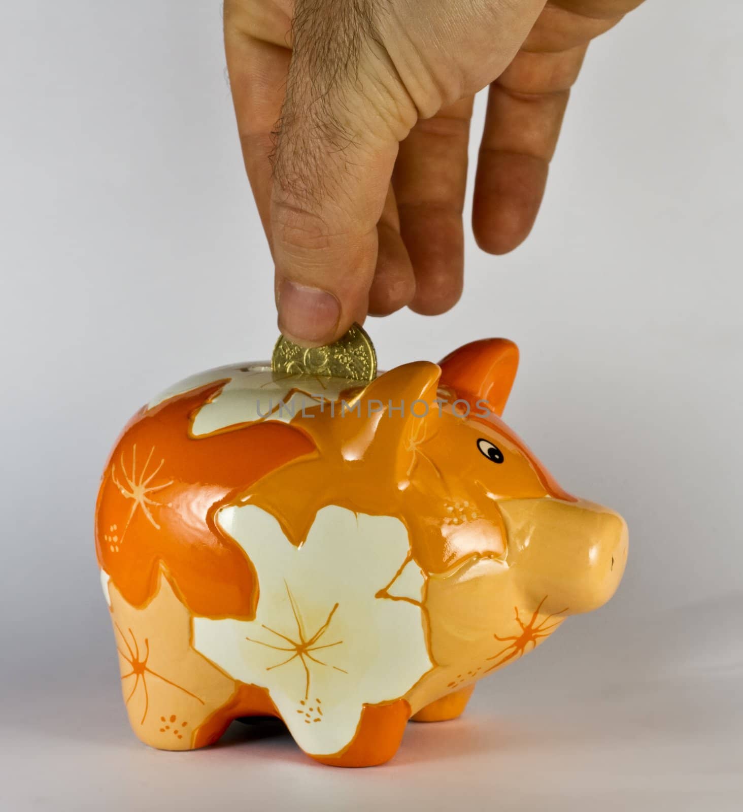saving money by putting a coin in piggy bank