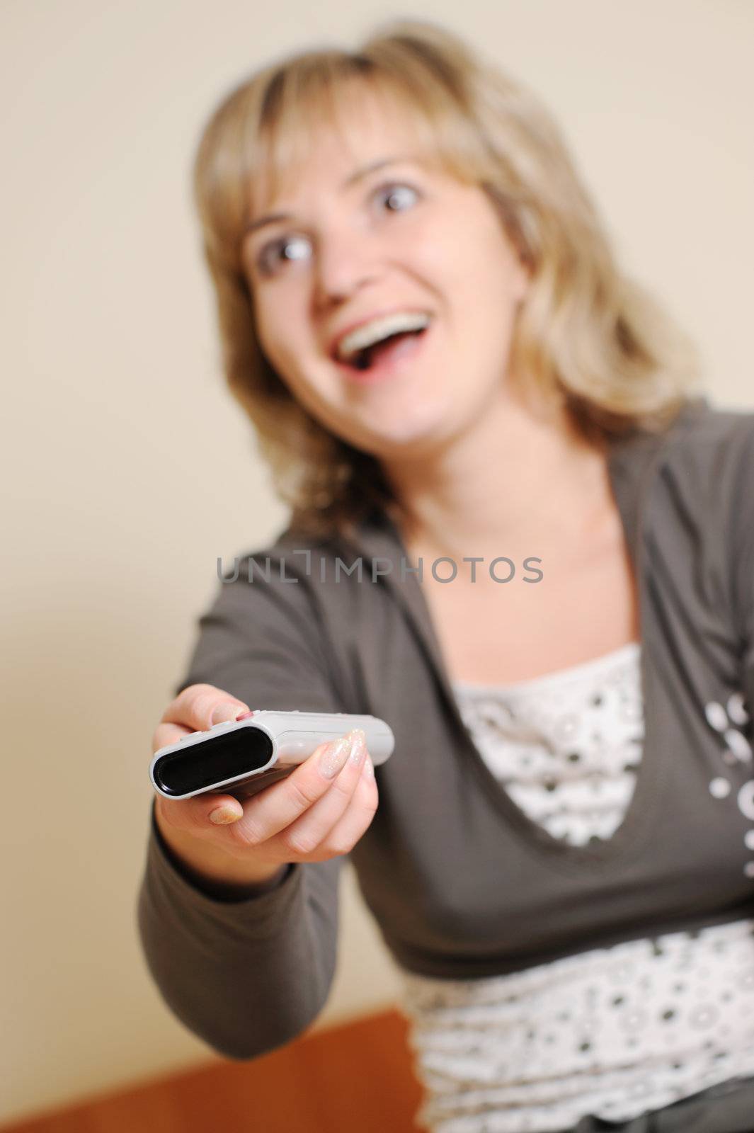 The woman with a television control panel. House conditions. Selective focus