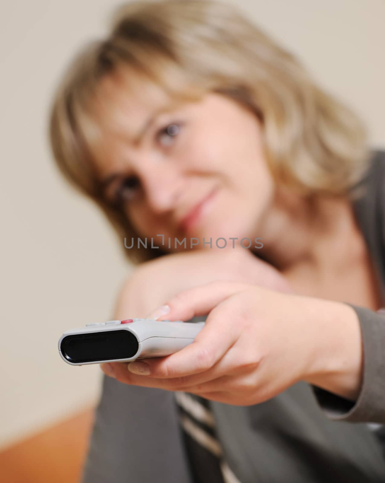 The woman with a television control panel. House conditions. Selective focus