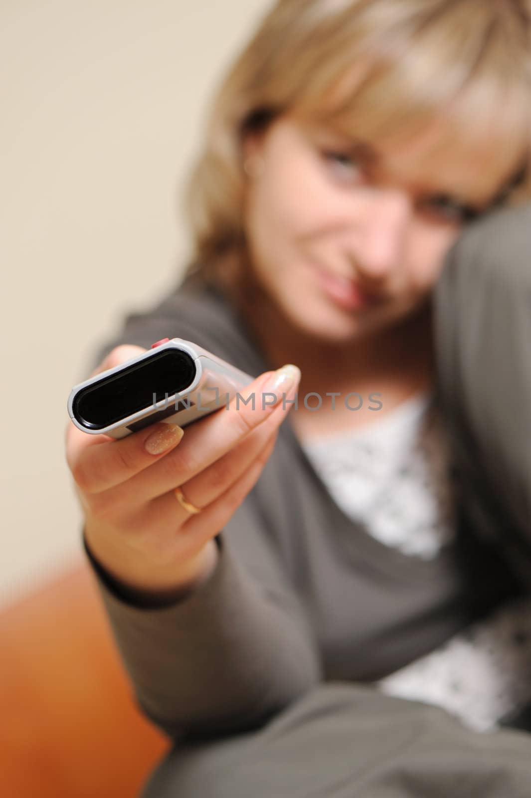 The woman with a television control panel. Selective focus by galdzer