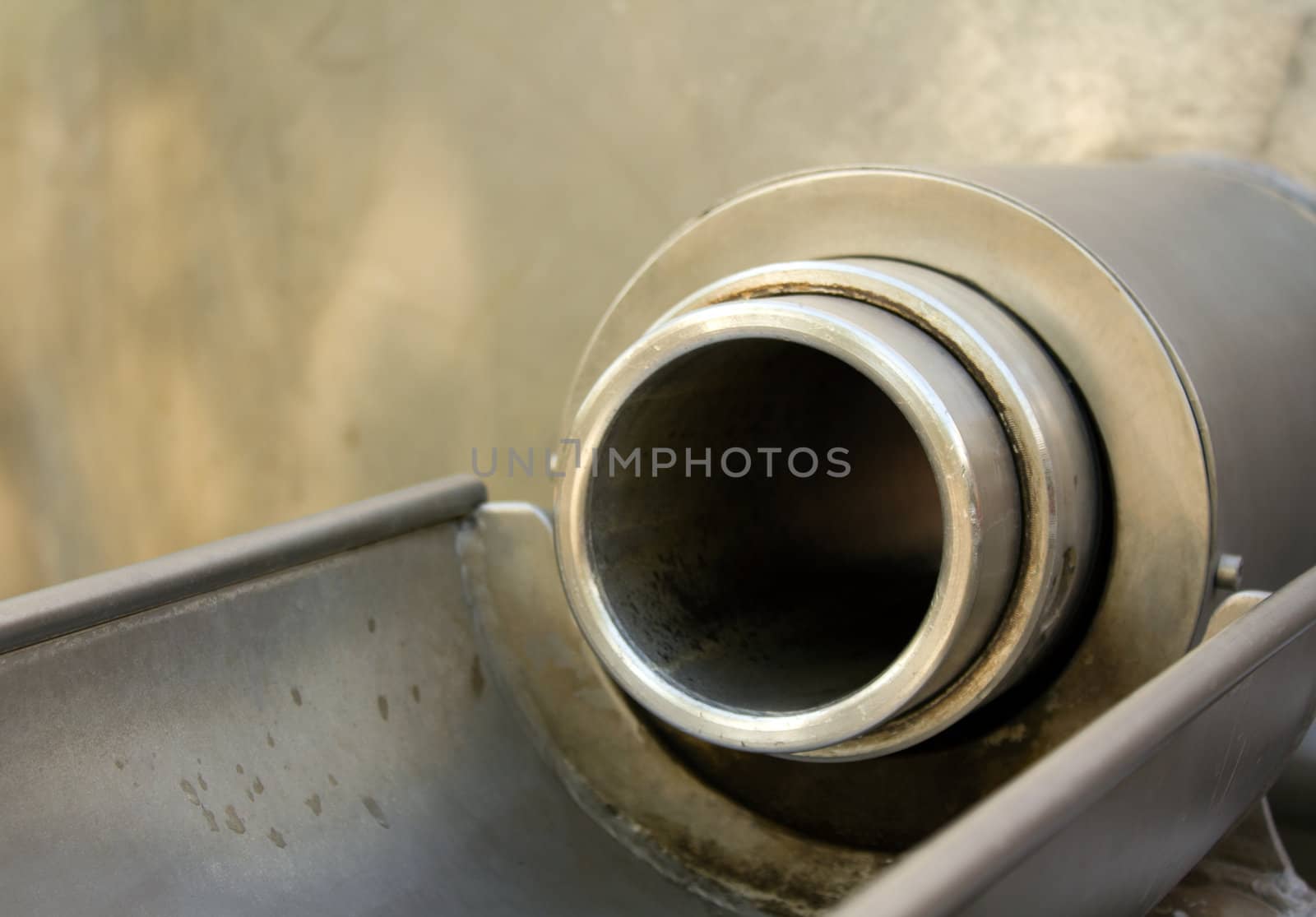 An outlet to an industrial pipe glistens in the sun