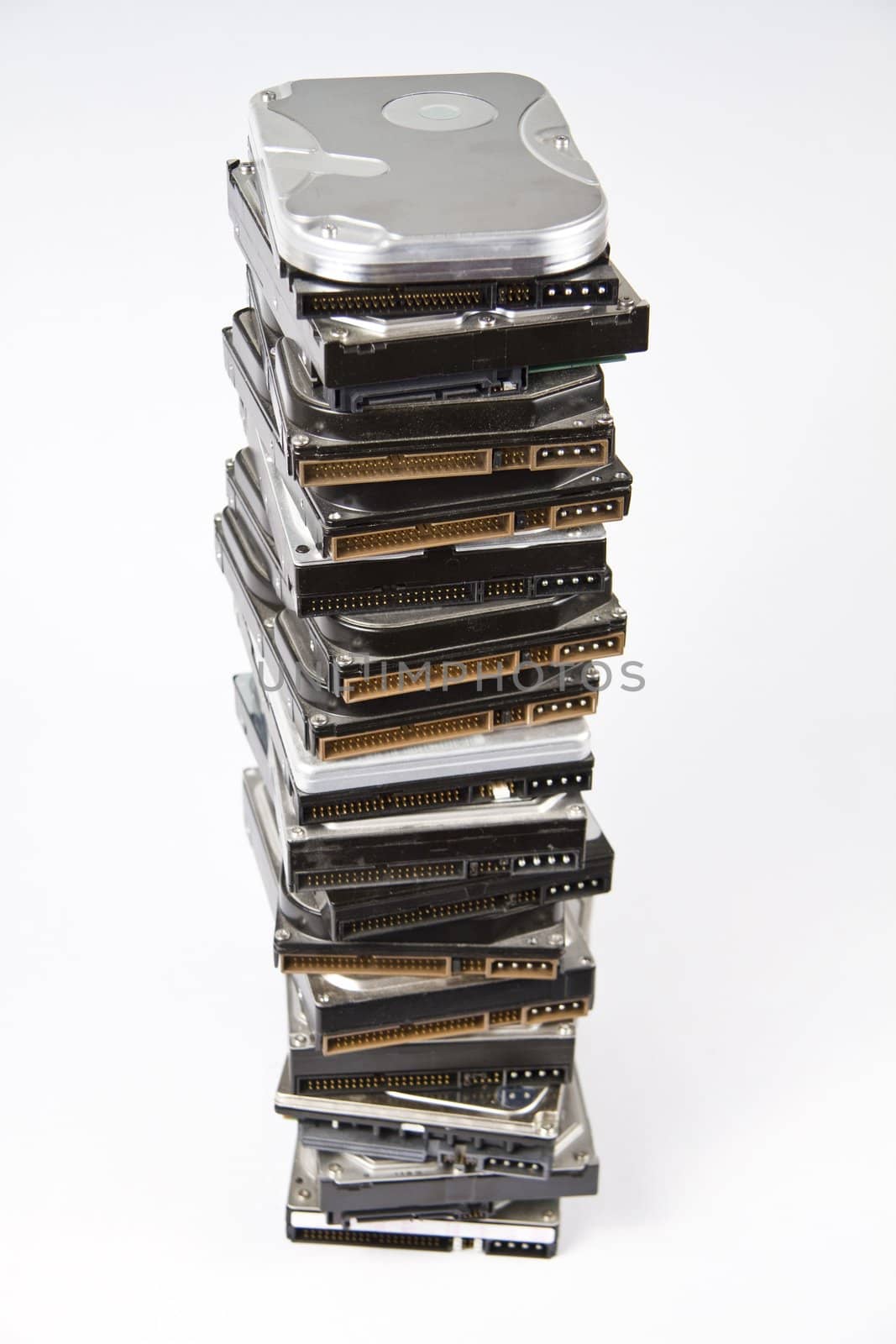 Stack of many different hard drives with opened drives on top.