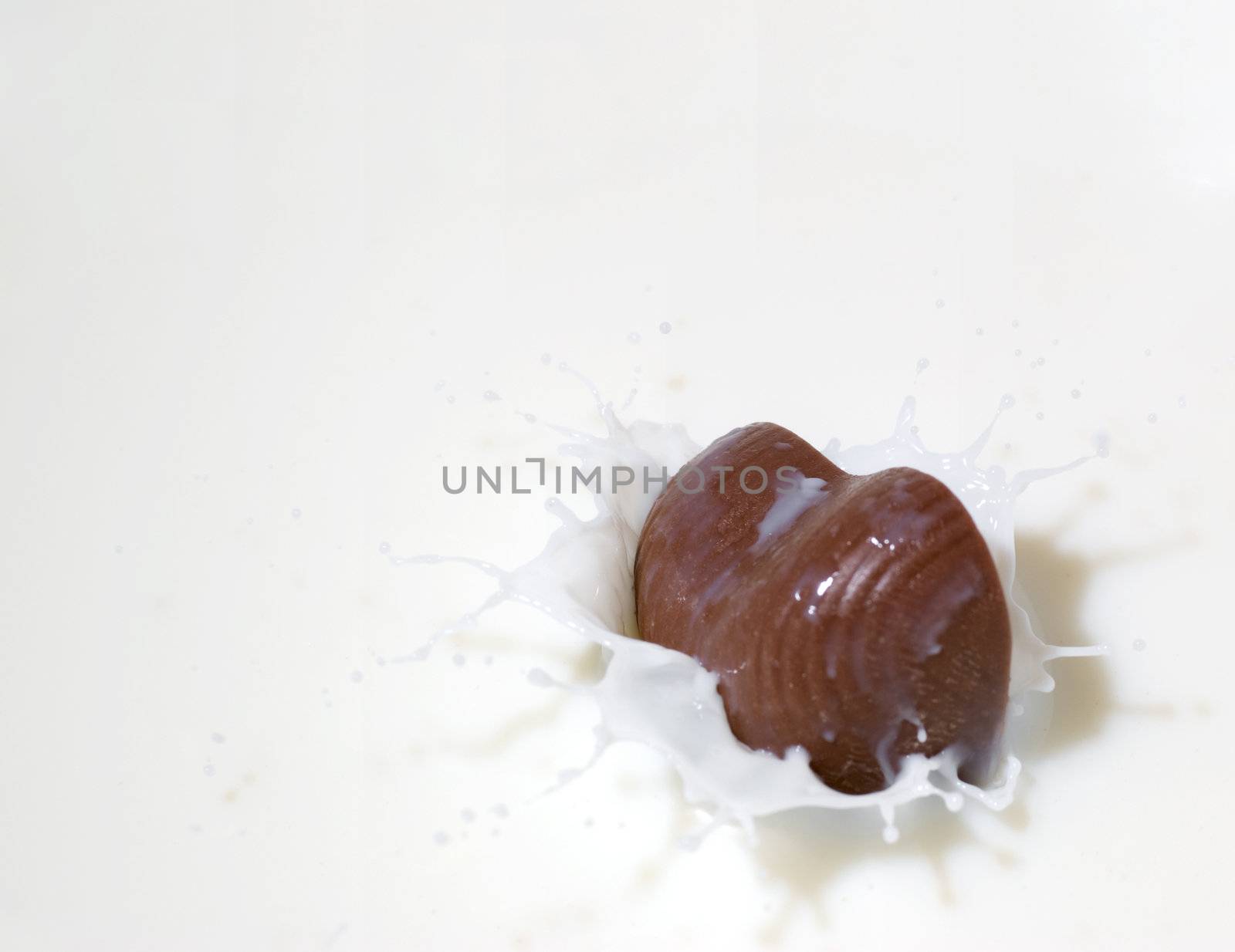 Chocolate heart and milk. Splash in a falling sweet in milk
