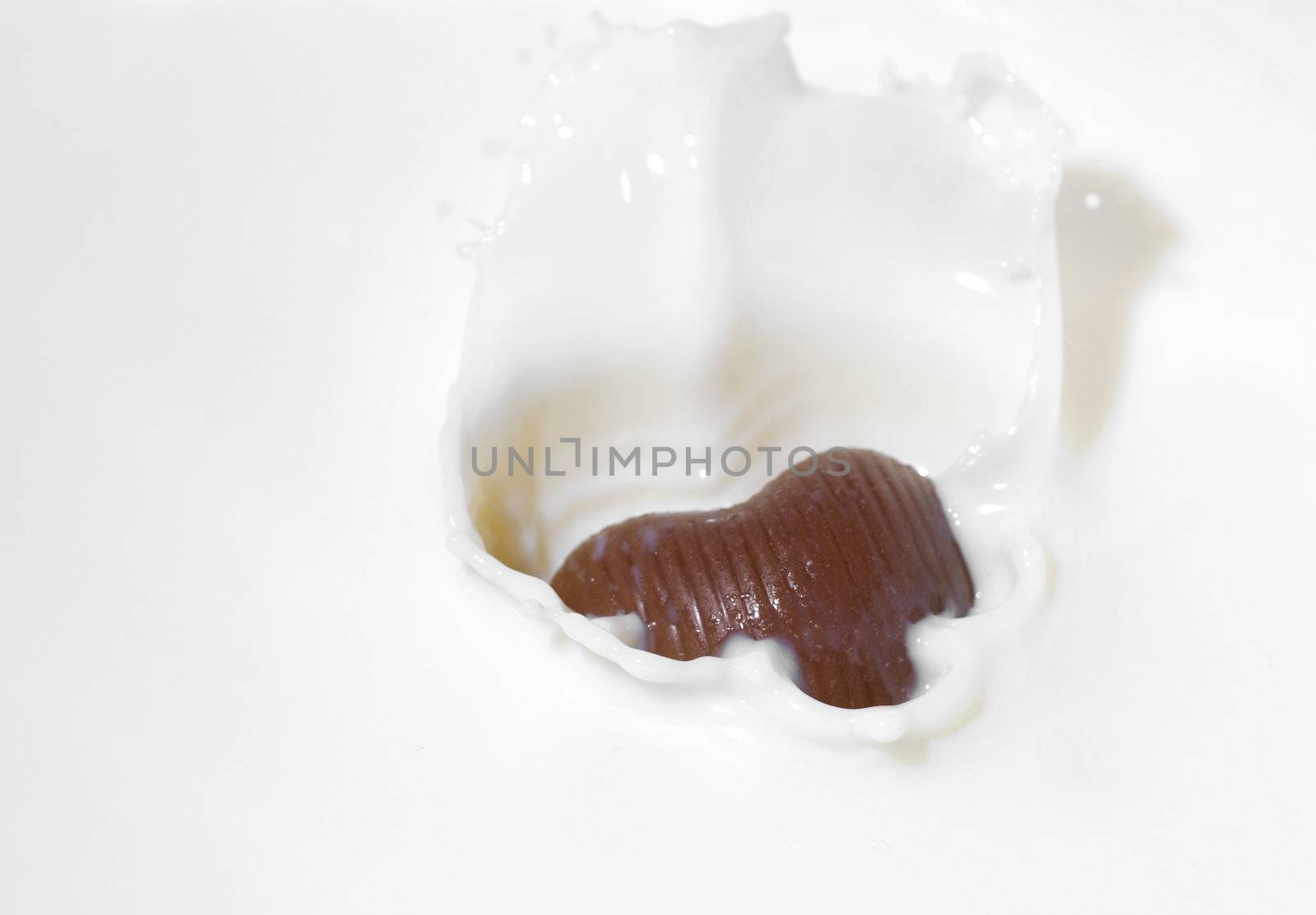 Chocolate heart and milk. Splash in a falling sweet in milk
