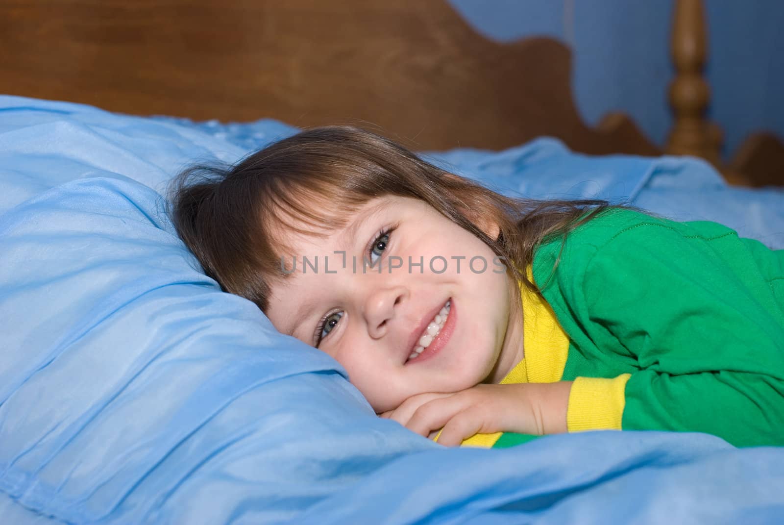 The little girl on a bed. The three-year child of the European nationality