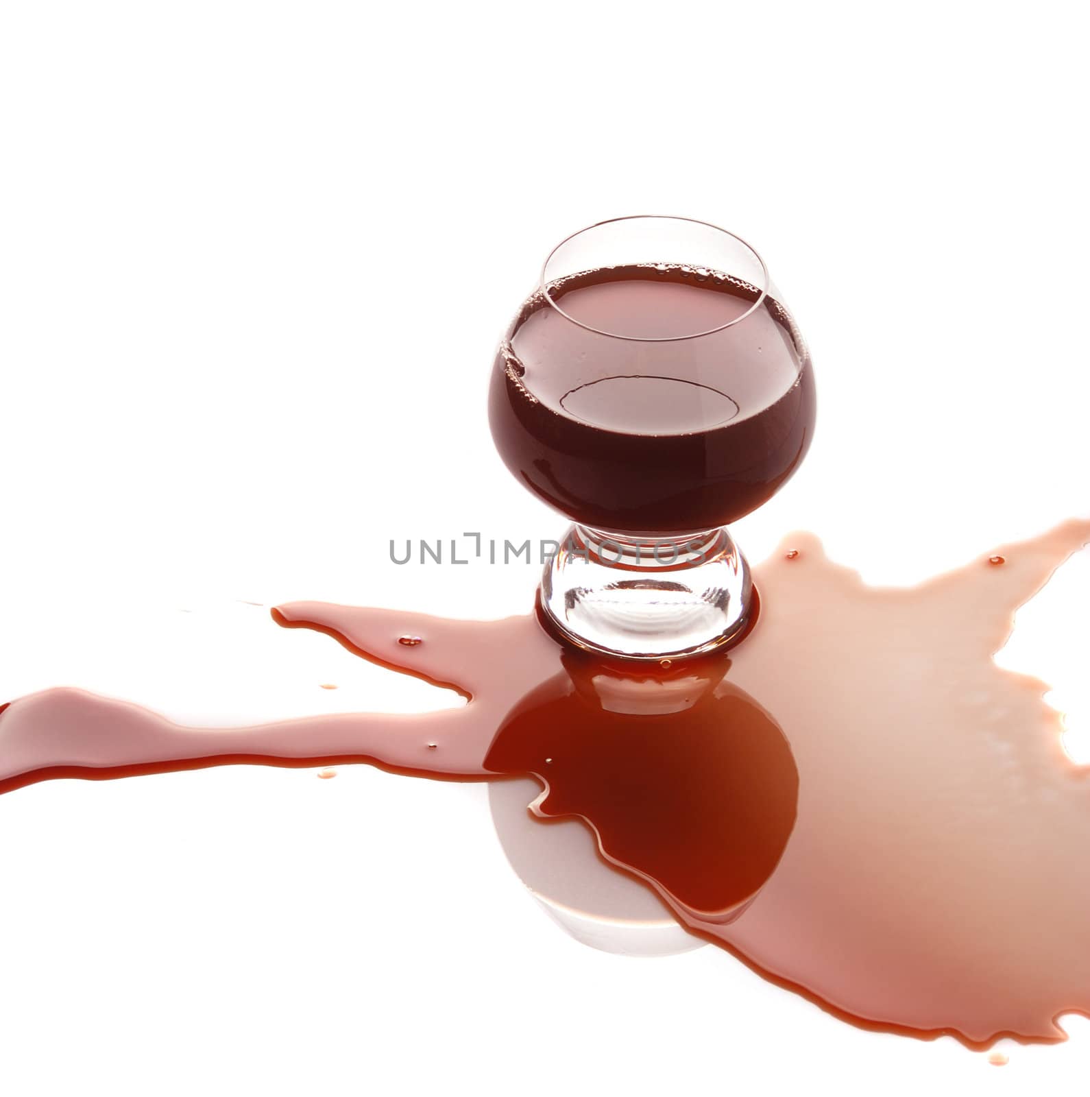 The spilled red wine. Wine poured on a surface, is isolated on a white background