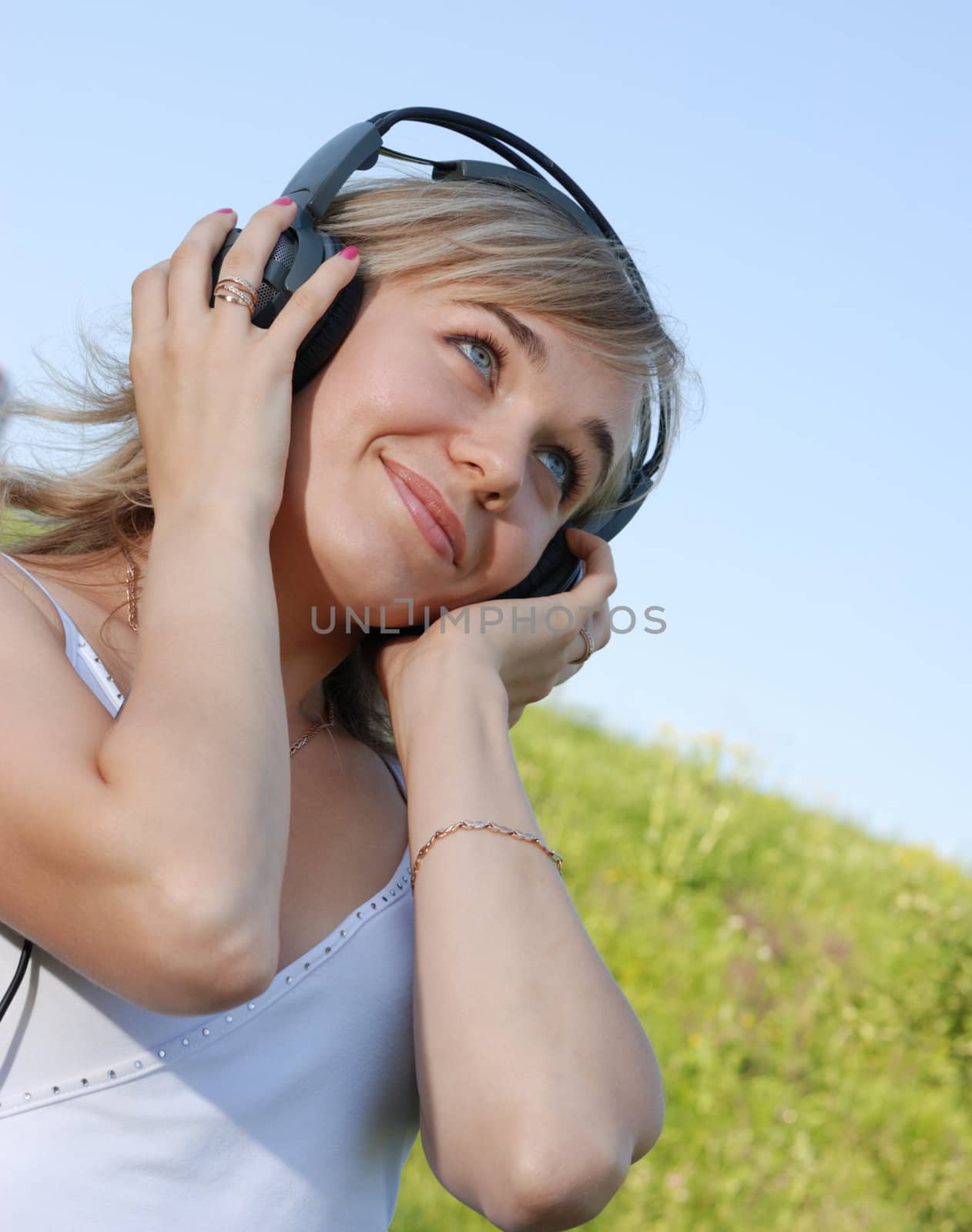 The girl in headphones. The young woman listening music through headphones