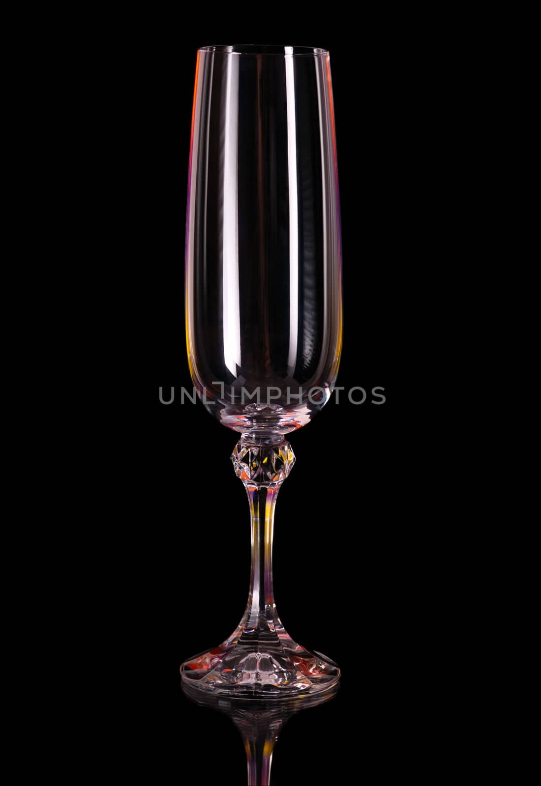 Wine glass. An empty glass on a dark background, with multi-coloured illumination