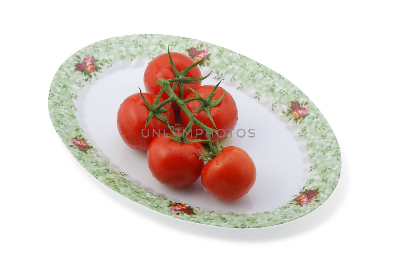 Tomato isolated at dish. It is isolated on a white background. A ripe vegetable.