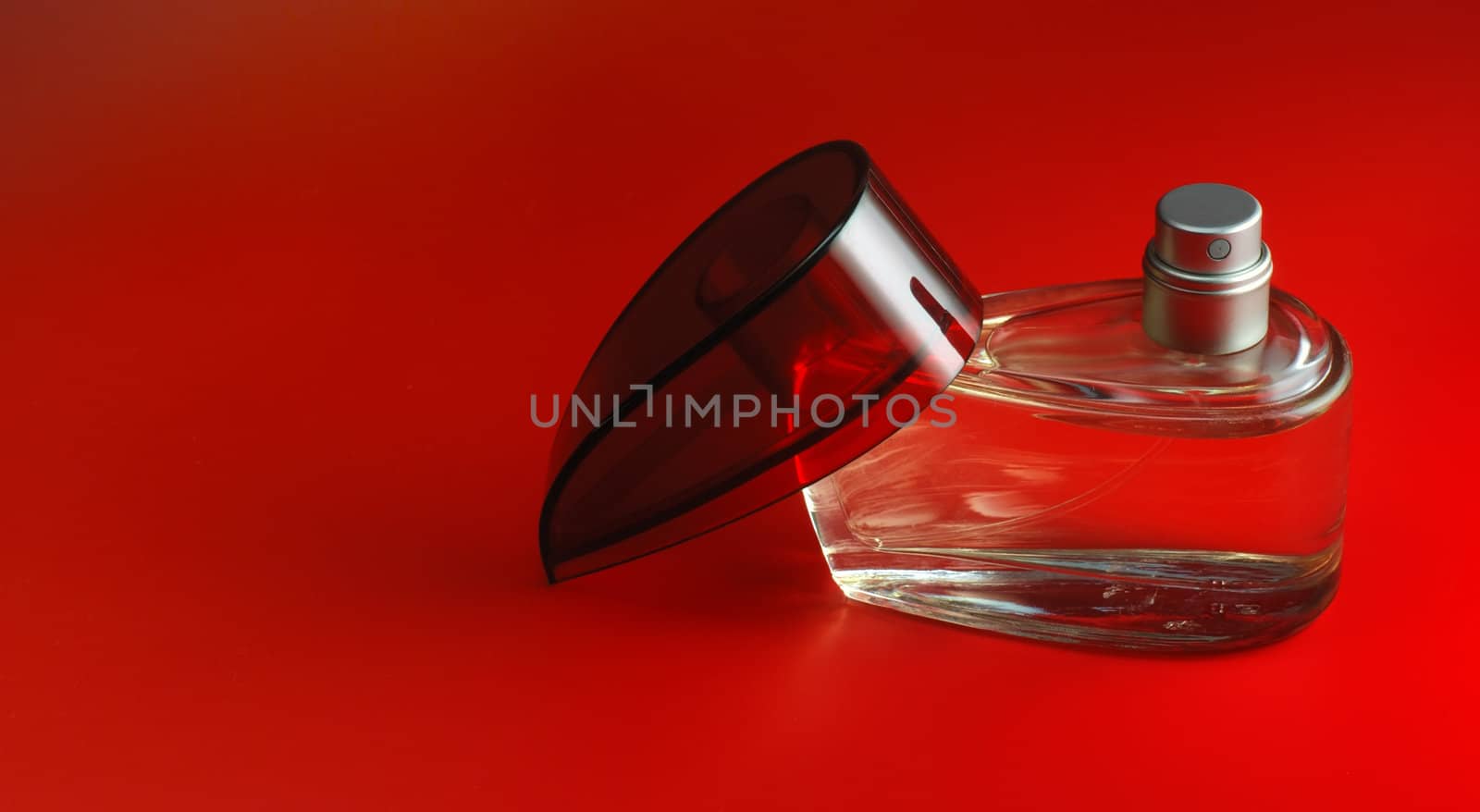 perfume. A bottle perfume on a red background with effective illumination