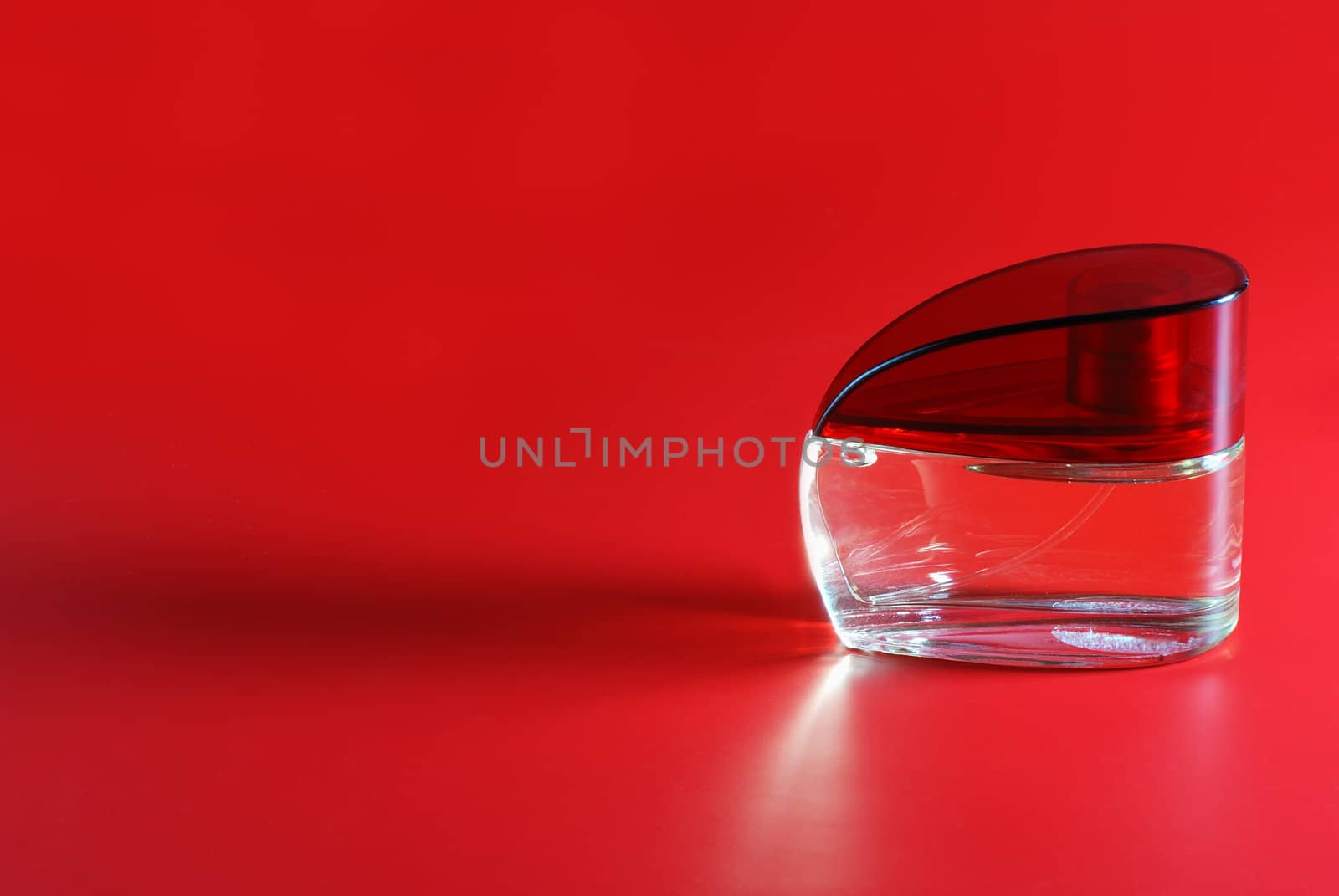 perfume. A bottle perfume on a red background with effective illumination